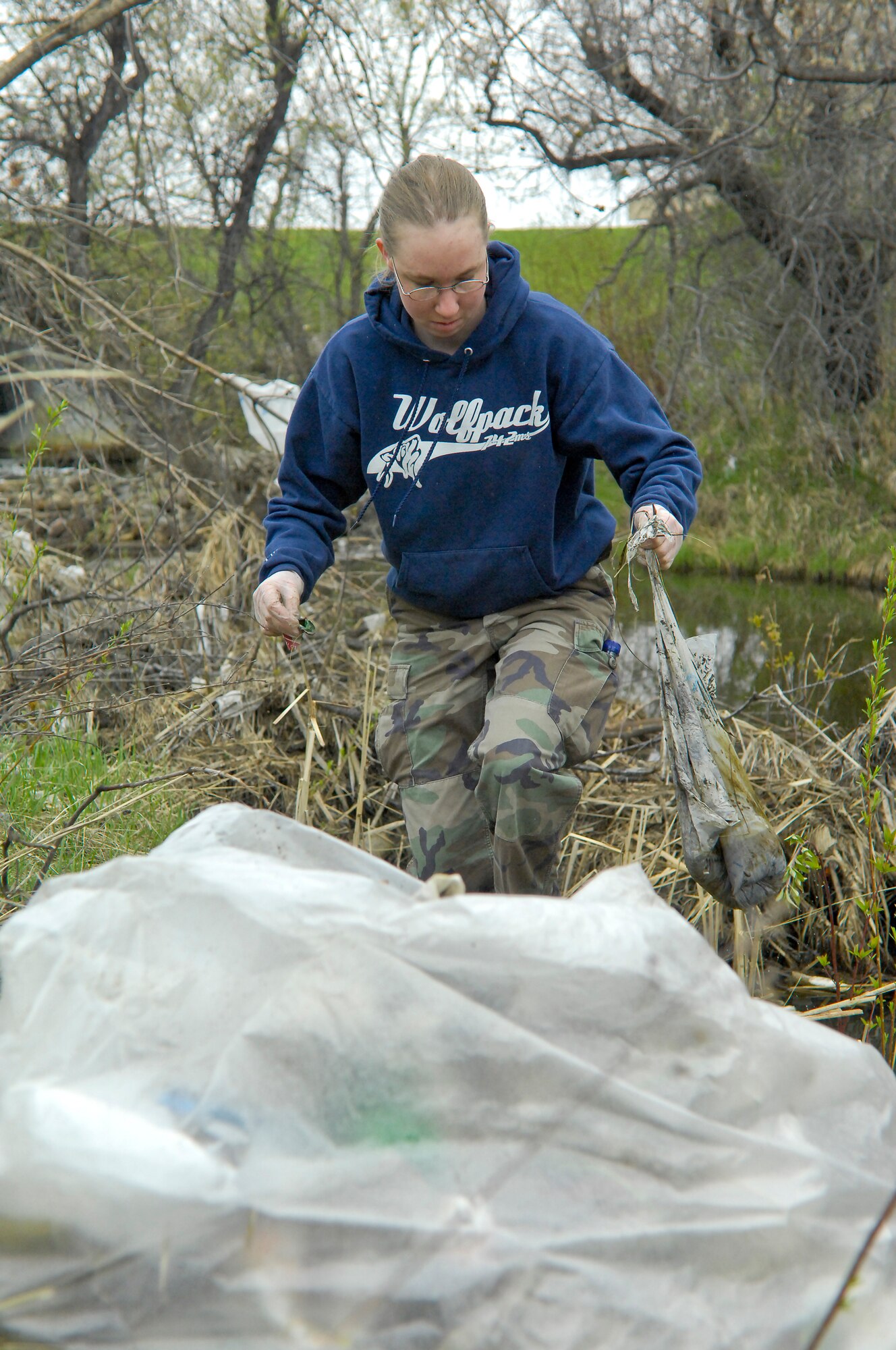 MINOT, N.D. -- Senior Airman Miranda Harris, 742nd Missile Squadron missile chef, picks up trash in a creek bed near the Dakota Square Mall here April 30. Team Minot joined together in an effort to clean up the city. A trash-free city is a sure way kids of all ages can enjoy the summer months after a long, hard North Dakota winter. (U.S. Air Force photo by Senior Airman Benjamin Stratton)