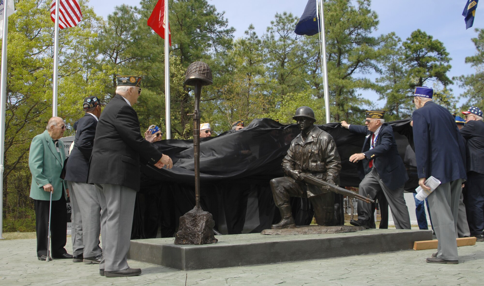 Members of the Manchester Township Veterans Advisory Committee unveil a monument  at World War II Veterans Memorial Park, in Manchester Township. The bronze statue is located at the center of the park. It depicts a World War II Soldier looking at  a weapon and helmet, representing a lost comrade. (U.S. Army/ 1st. Sgt. David Moore)

