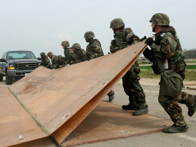 Airmen from the 51st Civil Engineer Squadron unfold a fiberglass mat after a simulated attack during Exercise Beverly Midnight 10-01 at Osan Air Base, Republic of Korea, May 4. The mats are used to quickly repair runway damage, and can be connected to cover larger areas. (U.S. Air Force photo/Staff Sgt. Stephenie Wade)