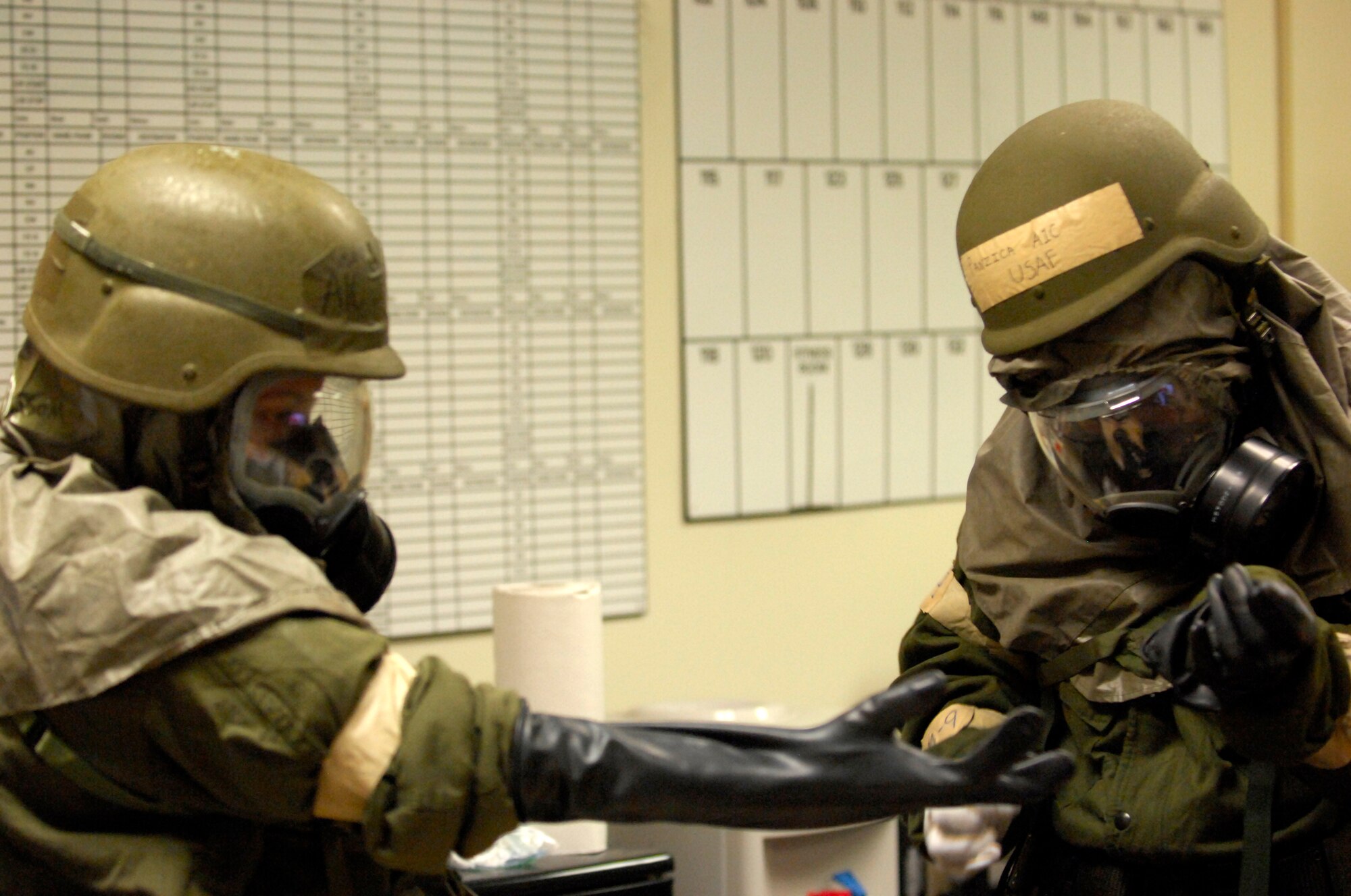 MINOT AIR FORCE BASE, N.D. -- Airman 1st Class Jessica Watson, 69th Bomb Squadron aviation manager, and Airman 1st Class Alyssa Panzica, 5th Operations Group knowledge operation manager, help each other put on mission oriented protective posture gear, also known as MOPP gear, during a base exercise here April 28. The focus of this exercise was to practice Ability to Survive and Operate, or ATSO skills. (U.S. Air Force photo by Senior Airman Ashley N. Avecilla) 