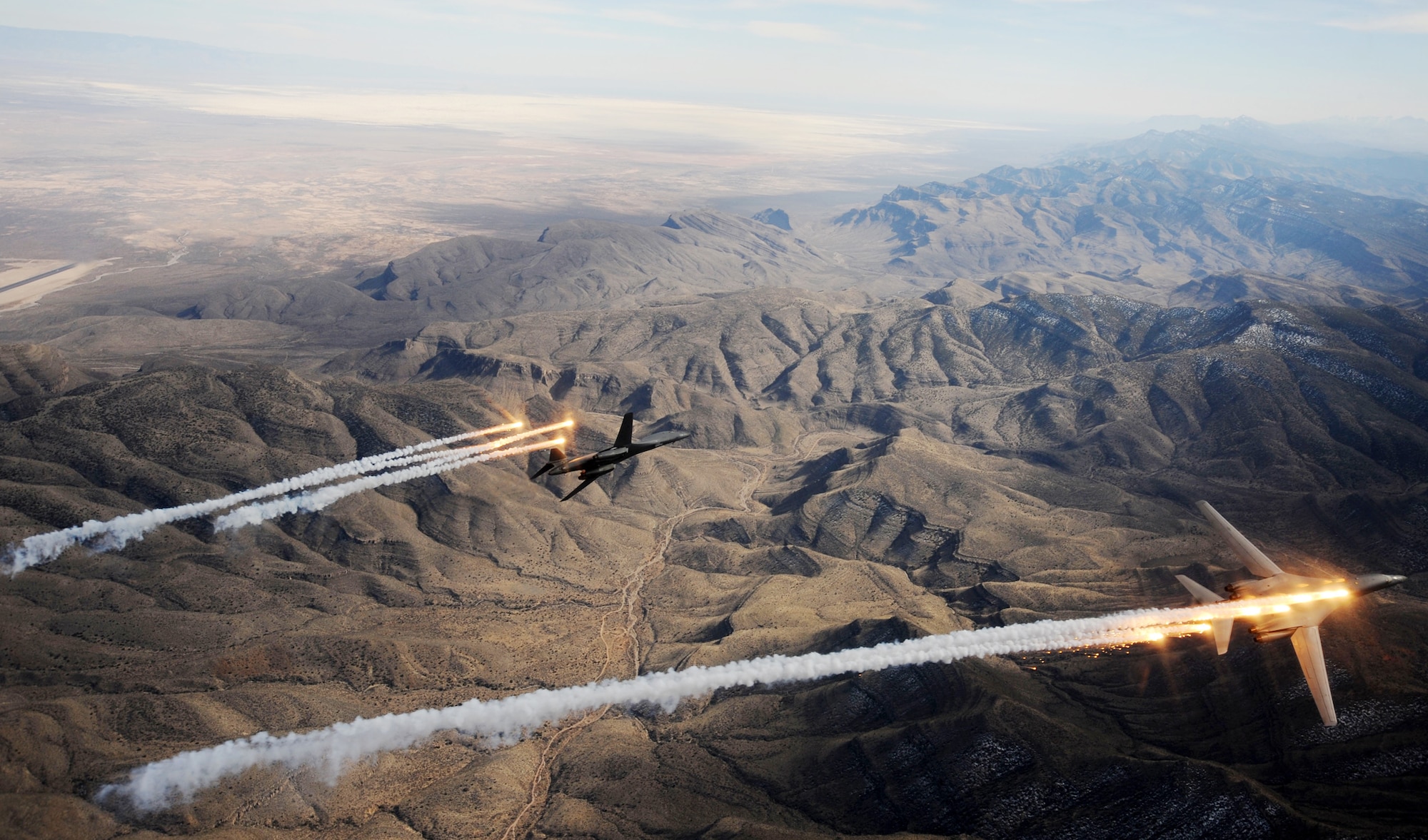 A two-ship formation of B-1B Lancers assigned to the 28th Bomb Squadron, Dyess Air Force Base, Texas, release chaff and flares while maneuvering over New Mexico during a training mission Feb. 24, 2010.  Dyess celebrates the 25th anniversary of the first B-1B bomber arriving at the base.  (U.S. Air Force photo/Master Sgt. Kevin J. Gruenwald) 