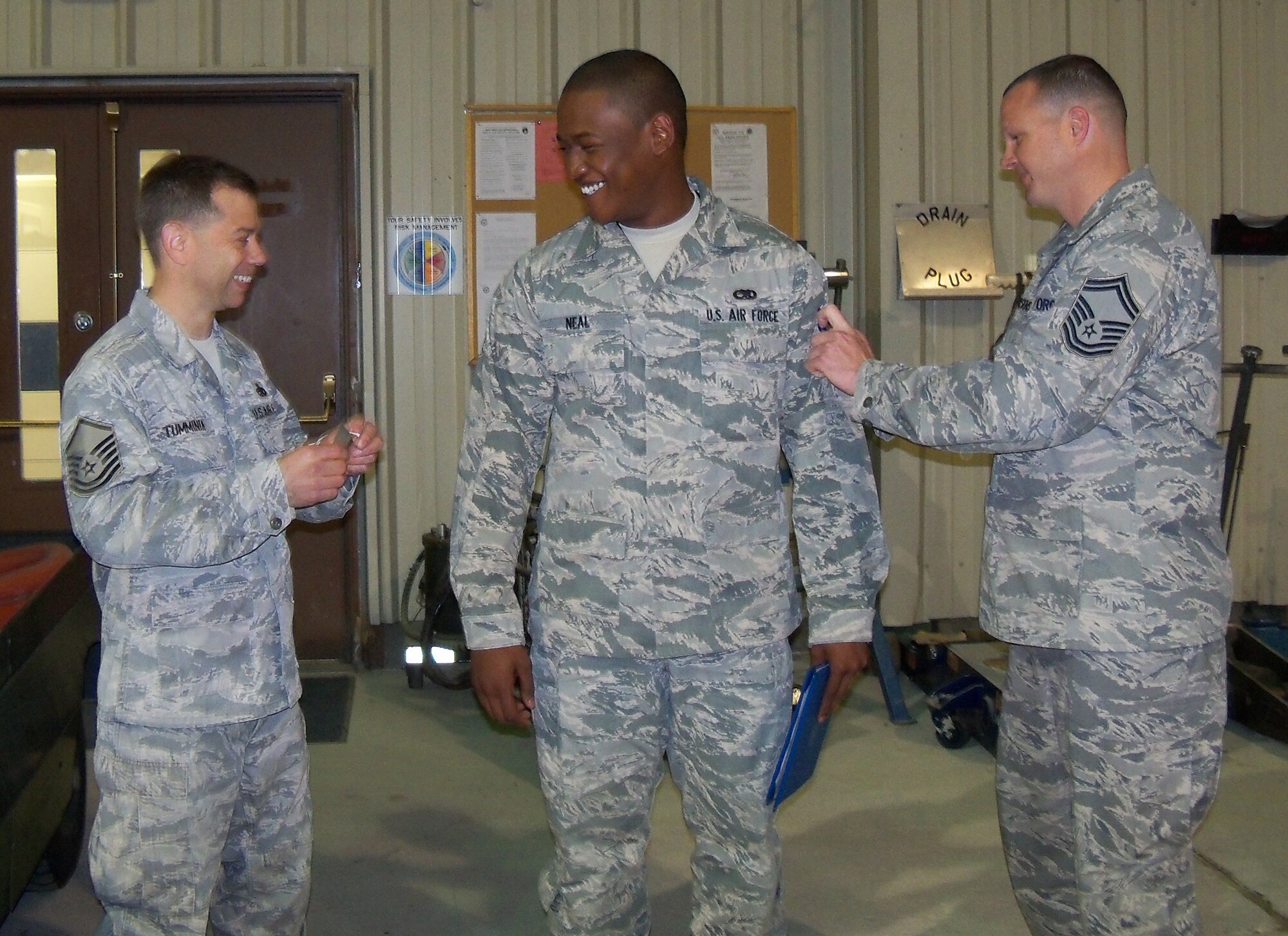 Airman First Class Eyan Neal, from 916th Fuel Cell, has his stripes tacked on by Senior Master Sgt. Luke Hoskins and Master Sgt. Gary Tumminia during a recent drill weekend. (USAF photo courtesy of 916 MXS).