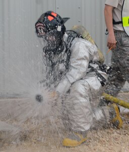Airman 1st Class Ryan O'Grady, from the 902nd Fire and Emergency Squadron at Randolph Air Force base, TX, turns on fire hose as he prepares to enter a burning  building during structural fire fighter training. (U.S. Air force Photo By Don Lindsey)