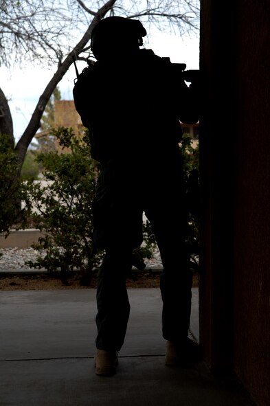 HOLLOMAN AIR FORCE BASE, N.M. -- A member of the El Paso Federal Bureau of Investigation peaks around the corner during a hostage exercise April 28, 2010, at the base dormitories. The exercise involved 49th SFS Quick Reaction Force members, 49th SFS hostage negotiators; FBI hostage negotiators and FBI Special Weapons and Tactics teams from El Paso, Texas; Las Cruces and Albuquerque, N.M. Within the past year, Holloman security forces and the FBI have begun exercising joint Crisis Negotiation Team training.  This was the first exercise of its kind at Holloman involving both Crisis Negotiation and the SWAT teams. Future exercises are planned and will be larger in scope. (U.S. Air Force photo by Airman 1st Class Joshua Turner / Released)     