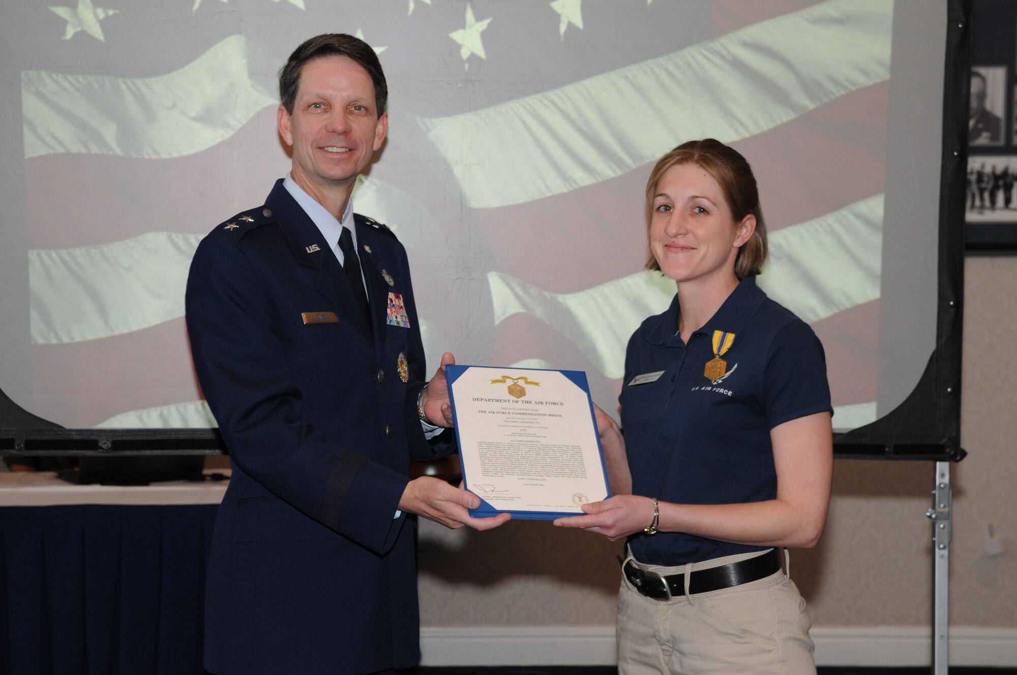Air Force District of Washington Commander Maj. Gen. Darrell Jones presents the Meritorious Service Medal to Tech. Sgt. Patricia Ogletree during the AFDW commander’s call April 30 at the Bolling Club. (U.S. Air Force photo by Thomas Dennis)