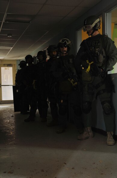 HOLLOMAN AIR FORCE BASE, N.M. -- Members of the Albuquerque Federal Bureau of Investigation wait for a call to implement their plan during a hostage exercise April 28, 2010, at the base dormitories. The exercise involved 49th SFS Quick Reaction Force members, 49th SFS hostage negotiators; FBI hostage negotiators and FBI Special Weapons and Tactics teams from El Paso, Texas; Las Cruces and Albuquerque, N.M. Within the past year, Holloman security forces and the FBI have begun exercising joint Crisis Negotiation Team training.  This was the first exercise of its kind at Holloman involving both Crisis Negotiation and the SWAT teams. Future exercises are planned and will be larger in scope. (U.S. Air Force photo by Airman 1st Class Joshua Turner / Released)     