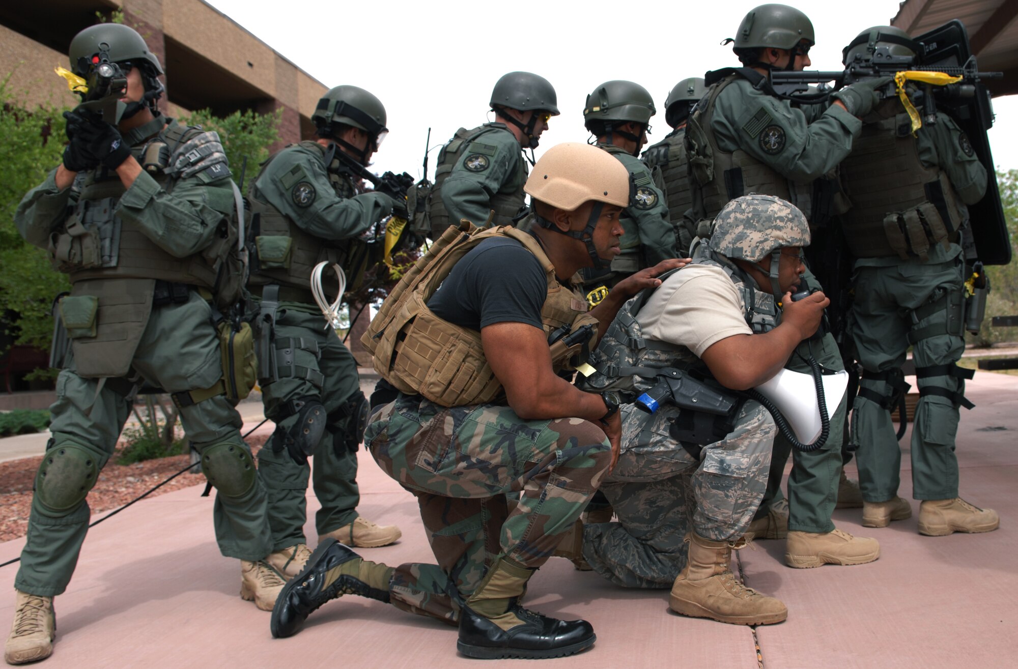 HOLLOMAN AIR FORCE BASE, N.M. -- Tech. Sgt. Antoine Washington and Staff Sgt. Ernst Francois , 49th Security Forces Squadron, negotiate with the alleged perpetrator during a hostage exercise while the El Paso Federal Bureau of Investigation safeguard them April 28, 2010, at the base dormitories. The exercise involved 49th SFS Quick Reaction Force members, 49th SFS hostage negotiators; FBI hostage negotiators and FBI Special Weapons and Tactics teams from El Paso, Texas; Las Cruces and Albuquerque, N.M. Within the past year, Holloman security forces and the FBI have begun exercising joint Crisis Negotiation Team training.  This was the first exercise of its kind at Holloman involving both Crisis Negotiation and the SWAT teams. Future exercises are planned and will be larger in scope. (U.S. Air Force photo by Airman 1st Class Joshua Turner / Released)     