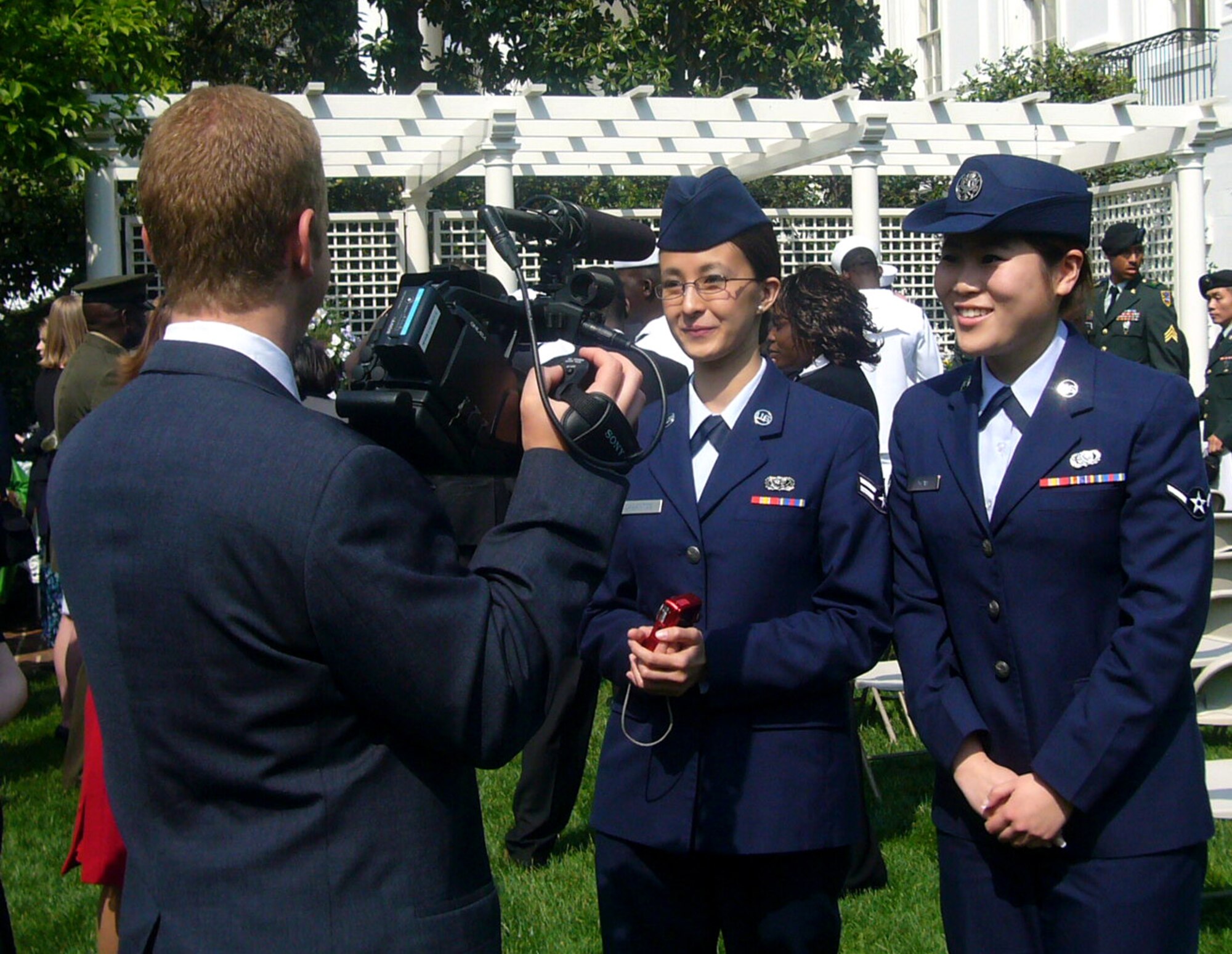 WASHINGTON, D.C. -- Airman 1st Class Ma Antonette Cabantog, 633d Force Support Squadron food services journeyman, and Airman Yu Yuan, 735th Supply Chain Management Group mission capability apprentice, perform an interview at the Oath of Allegiance ceremony at the White House April 23. The Airmen joined 22 other servicemembers in taking the Oath of Allegiance, becoming American citizens. (Courtesy photo)
