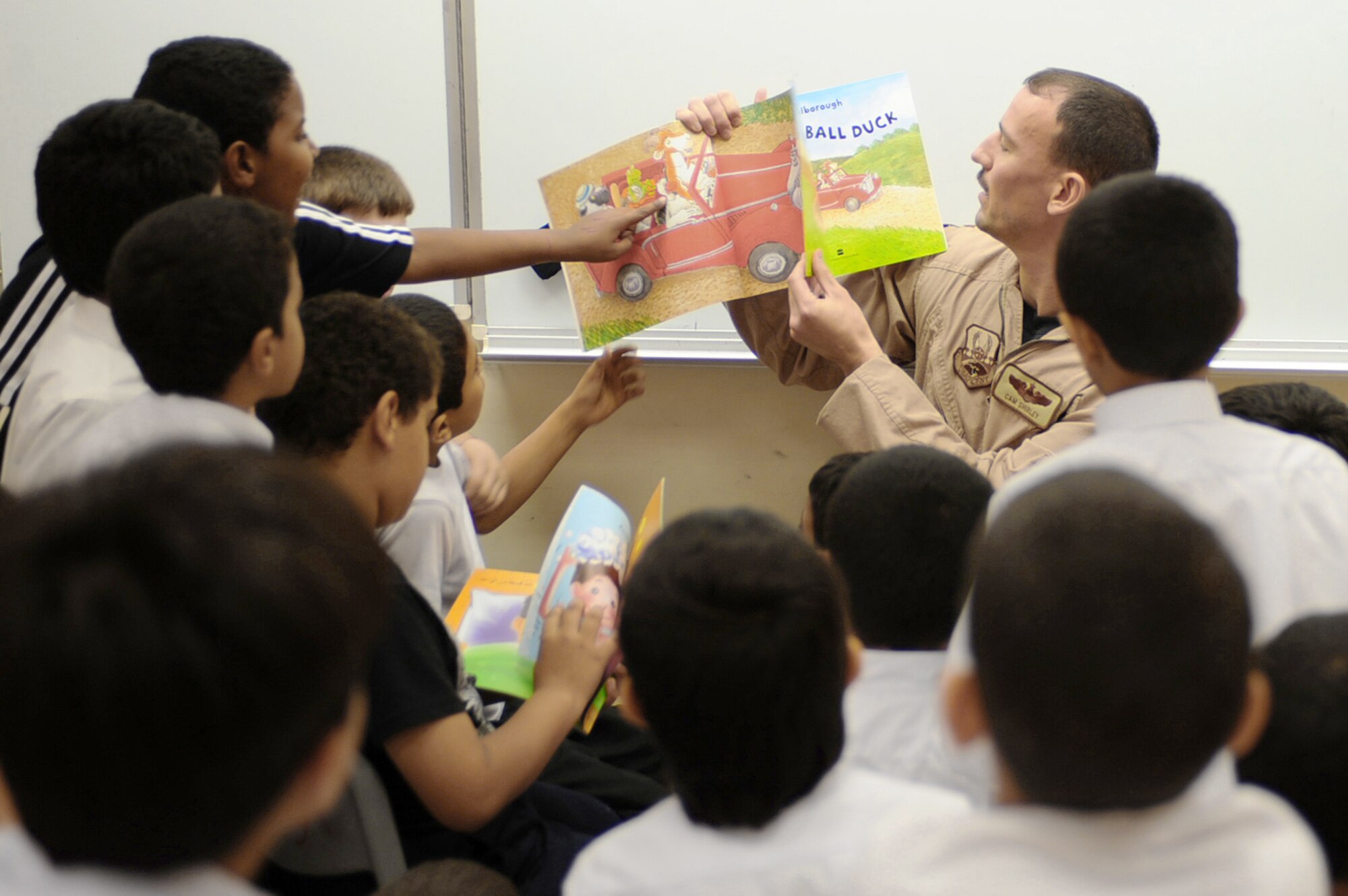 Maj. Cam Shirley reads a book to a group of third-grade boys during "Book Week" April 19, 2010, at a host-nation school in Southwest Asia. The Goodwill Ambassador Team of Arabic-speakers is open to all U.S. and coalition members interested in fostering good community relations with the host-nation public. Major Shirley is a 34th Expeditionary Bomb Squadron pilot and member of the 379th Air Expeditionary Wing's newly-formed Goodwill Ambassador Team. (U.S. Air Force photo/Senior Airman Kasey Zickmund)