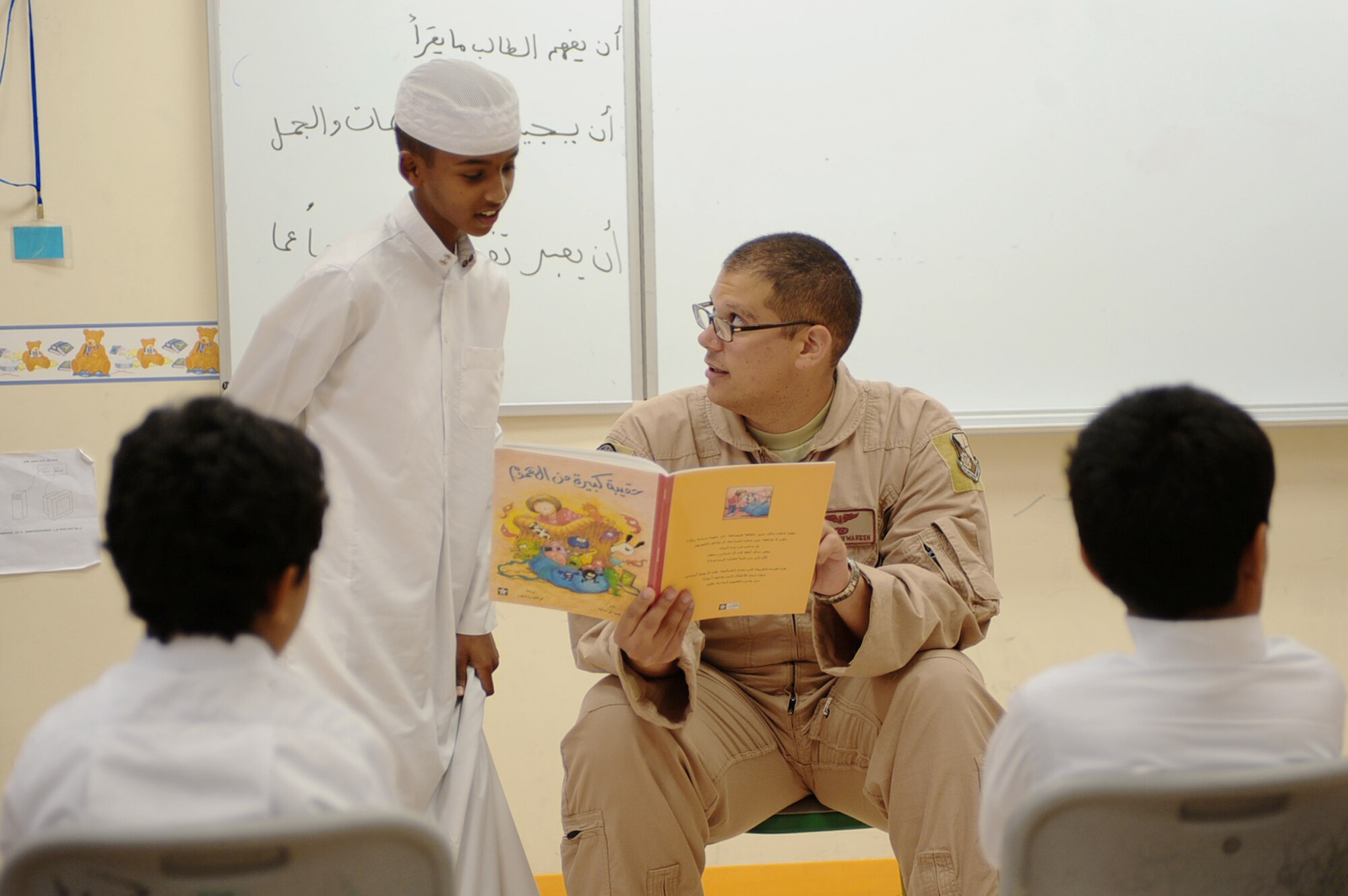 Senior Airman Joseph Warren reads a book aloud while a third-grader assists him with his Arabic during "Book Week" April 19, 2010, at a host-nation school in Southwest Asia. The Goodwill Ambassador Team of Arabic-speakers is open to all U.S. and coalition members interested in fostering good community relations with the host-nation public. Airman Warren is a 763rd Expeditionary Reconnaissance Squadron linguist and member of the 379th Air Expeditionary Wing's newly-formed Goodwill Ambassador Team. (U.S. Air Force photo/Senior Airman Kasey Zickmund)