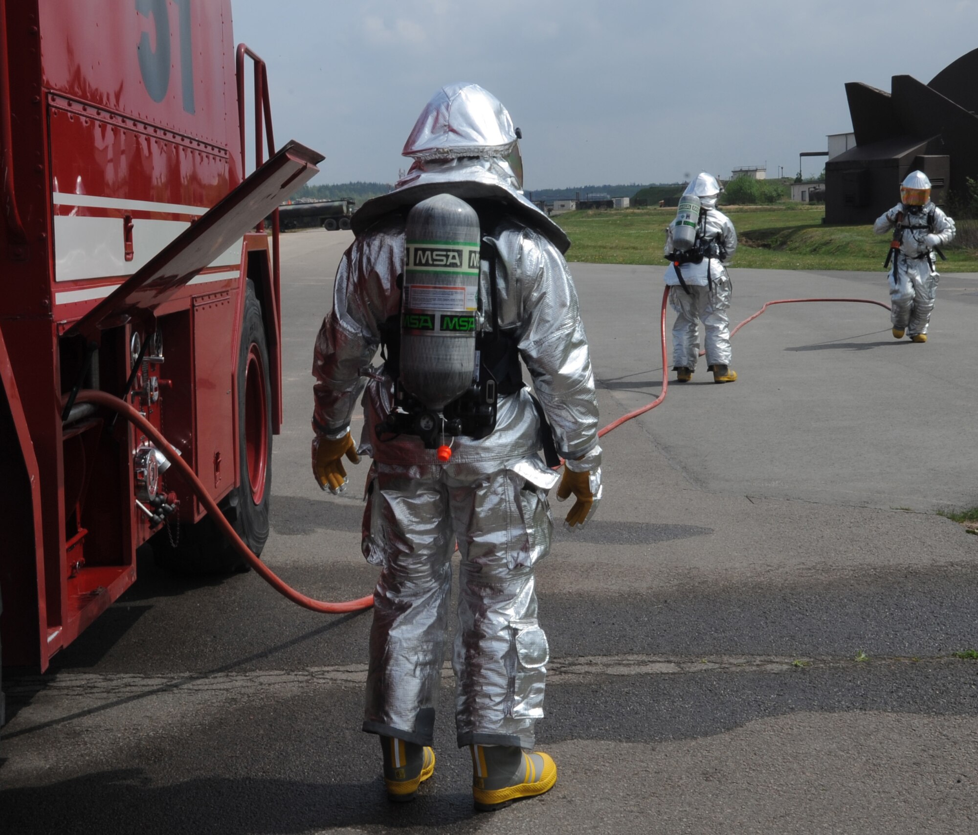 Firefighters from the 52nd Civil Engineer Squadron from Spangdahlem Air Base prepare hoses for a training exercise, Ramstein Air Base, Germany, May 4, 2010. Firefighters train on several different types of aircraft fire scenarios to become more proficient in containing and putting out aircraft fires. (U.S. Air Force Photos by Airman 1st Class Caleb Pierce)