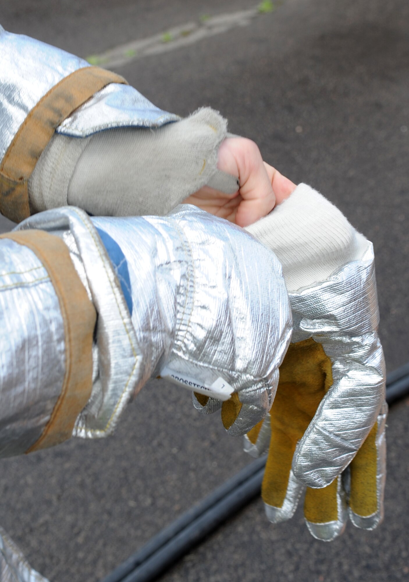U.S. Air Force Staff Sgt. Jack Toeller, 52nd Civil Engineer Squadron firefighter from Spangdahlem Air Base, puts on his protective gloves during a training exercise, Ramstein Air Base, Germany, May 4, 2010. Firefighters train on several different types of aircraft fire scenarios to become more proficient in containing and putting out aircraft fires. (U.S. Air Force Photos by Airman 1st Class Caleb Pierce)
