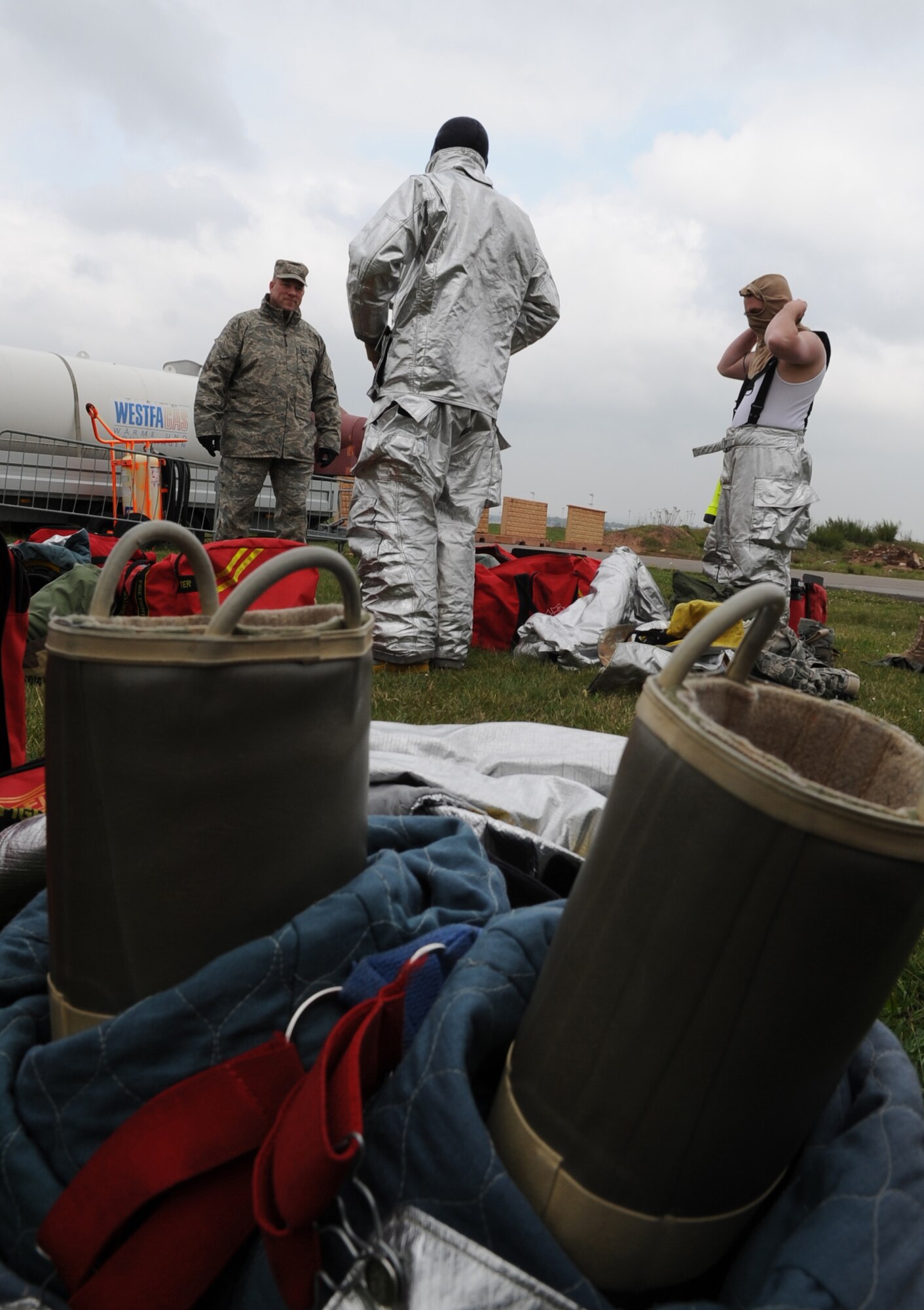 Firefighters from the 52nd Civil Engineer Squadron from Spangdahlem Air Base put on their protective fire suits during a training exercise, Ramstein Air Base, Germany, May 4, 2010. Firefighters train on several different types of aircraft fire scenarios to become more proficient in containing and putting out aircraft fires. (U.S. Air Force Photos by Airman 1st Class Caleb Pierce)