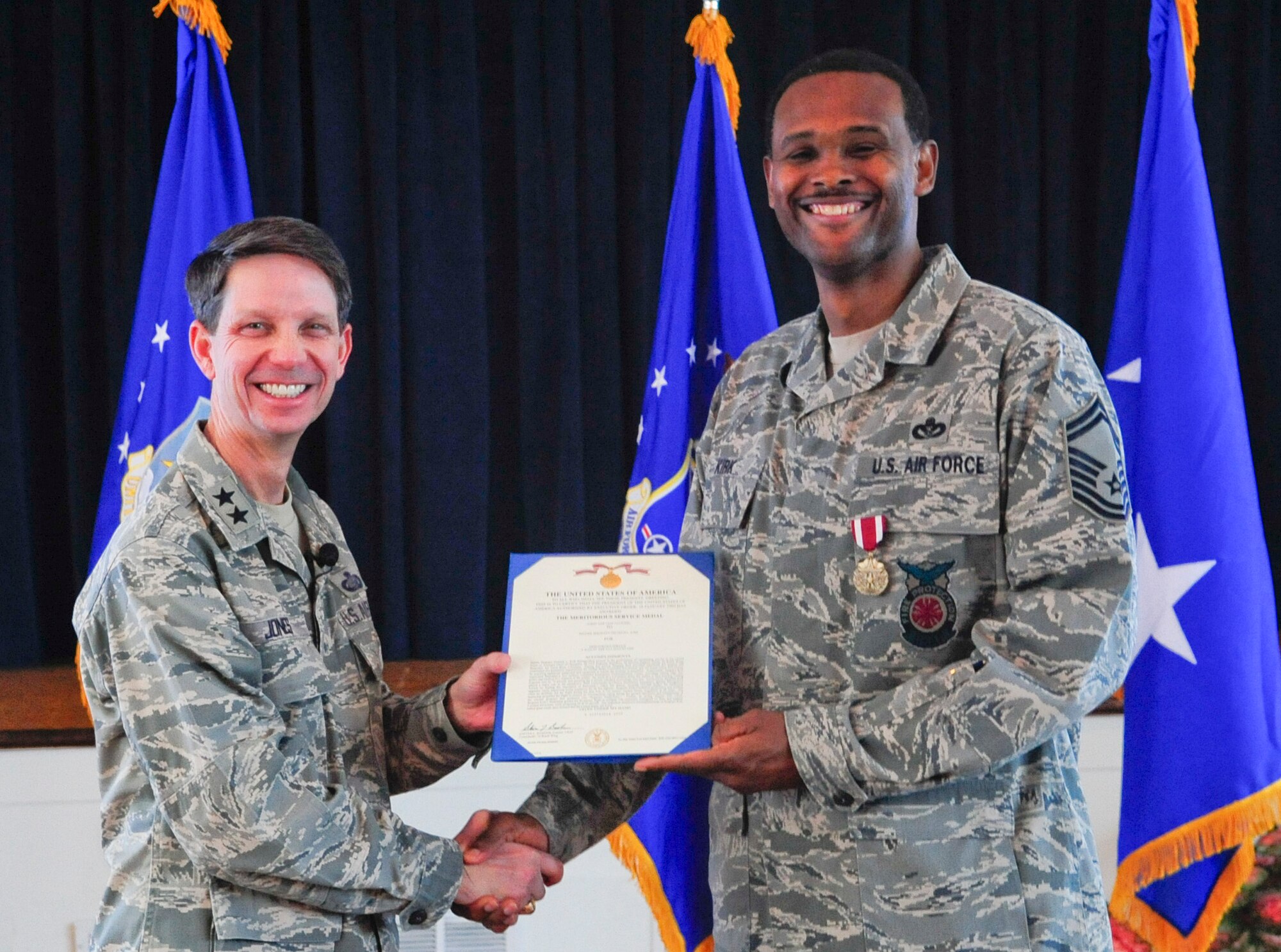 Air Force District of Washington Commander Maj. Gen. Darrell D. Jones, left, presented the Meritorious Service Medal to Senior Master Sgt. Dietrich  L. Kirk, AFDW Fire Chief during the AFDW commander’s call April 29, 2010 at the Community Center, Andrews AFB, Md. (U.S. Air Force photo by Staff Sgt. Corenthia K. Fennell)