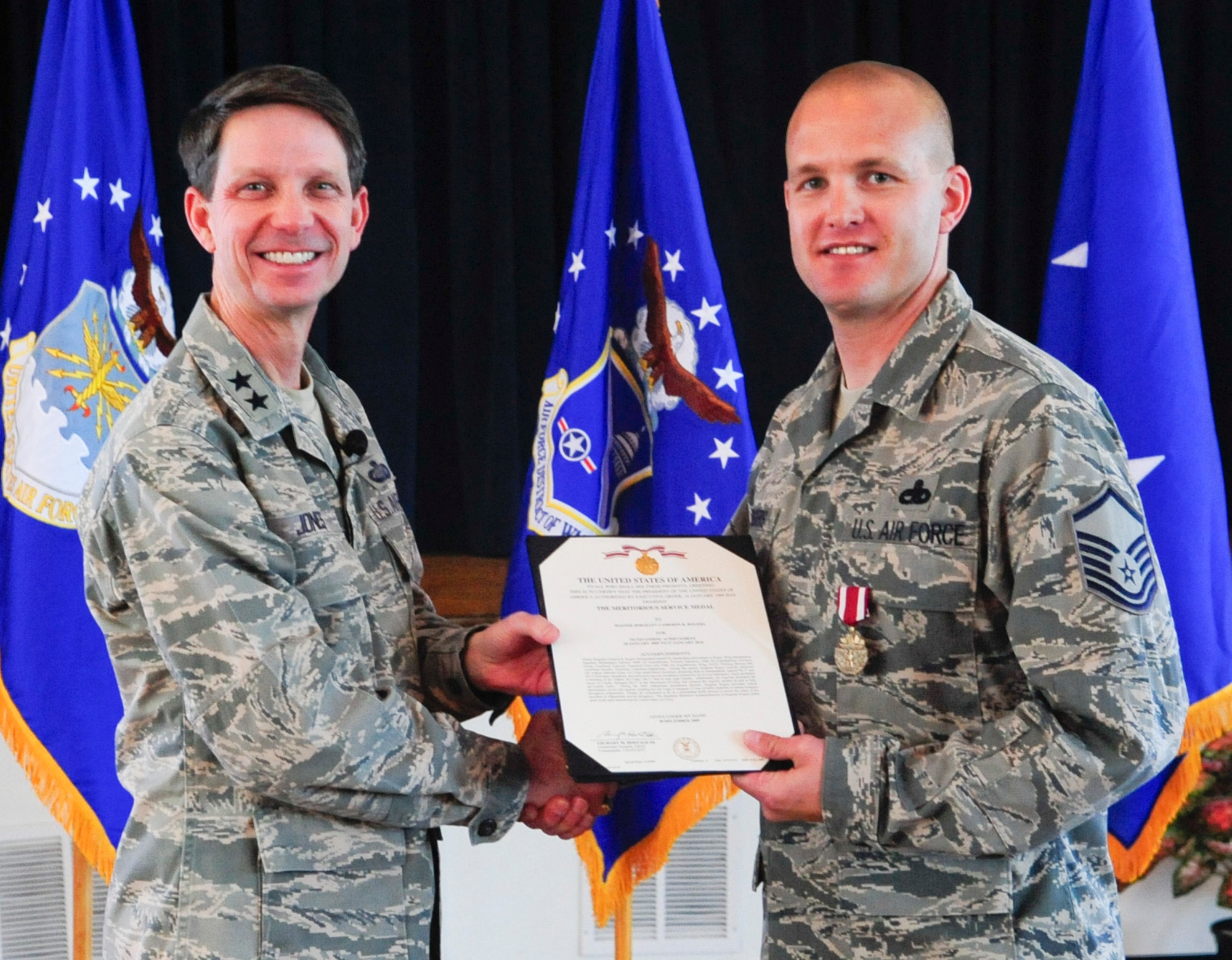Air Force District of Washington Commander Maj. Gen. Darrell D. Jones, left, presented the Meritorious Service Medal to Master Sgt. Cameron R. Rogers, AFDW Material Management during the AFDW commander’s call April 29, 2010 at the Community Center, Andrews AFB, Md. (U.S. Air Force photo by Staff Sgt. Corenthia K. Fennell)