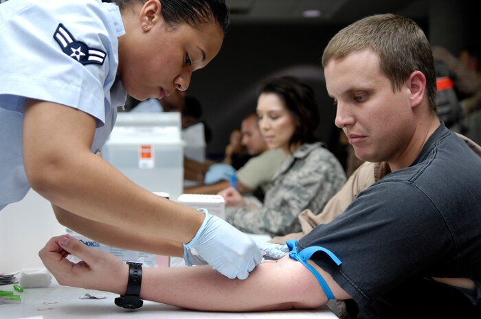 Capt. Michael Campbell sits patiently as Airman 1st Class Telisa Bell draws blood for a lab test at Joint Base Charleston, S.C., May 3, 2010. Captain Campbell recently returned from a deployment to the Middle East with the 14th Airlift Squadron. Airmen must file through a processing line to turn in their medical records and complete lab tests to ensure their health upon returning from a deployment. Airman Bell is a medical technician with the 628th Medical Group and Captain Campbell is a C-17 pilot with the 14th Airlift Squadron. (U.S. Air Force Photo/Airman 1st Class Lauren Main