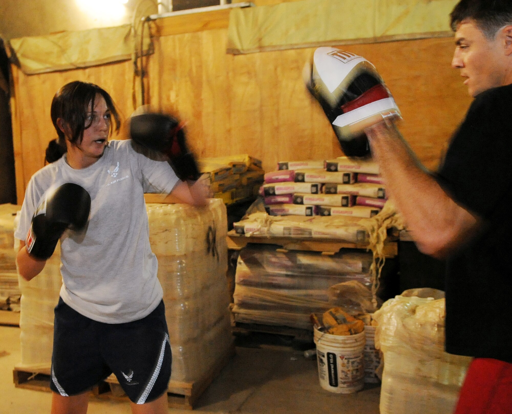Staff Sgt. Vincent Carll, 506th Expeditionary Civil Engineer Squadron heavy equipment operator, trains Staff Sgt. Sandra Mihovich, 506th Security Forces Squadron military working dog trainer, at Kirkuk Regional Air Base, Iraq on April 28, 2010.  Sergeant Carll uses his experience as a mixed martial arts cage fighter to train his fellow servicemember to fight in the upcoming Smoker 3 boxing tournament May 8.  He is deployed from Homestead Air Reserve Base, Fla.  (U.S. Air Force photo/Staff Sgt. Tabitha Kuykendall/Released)