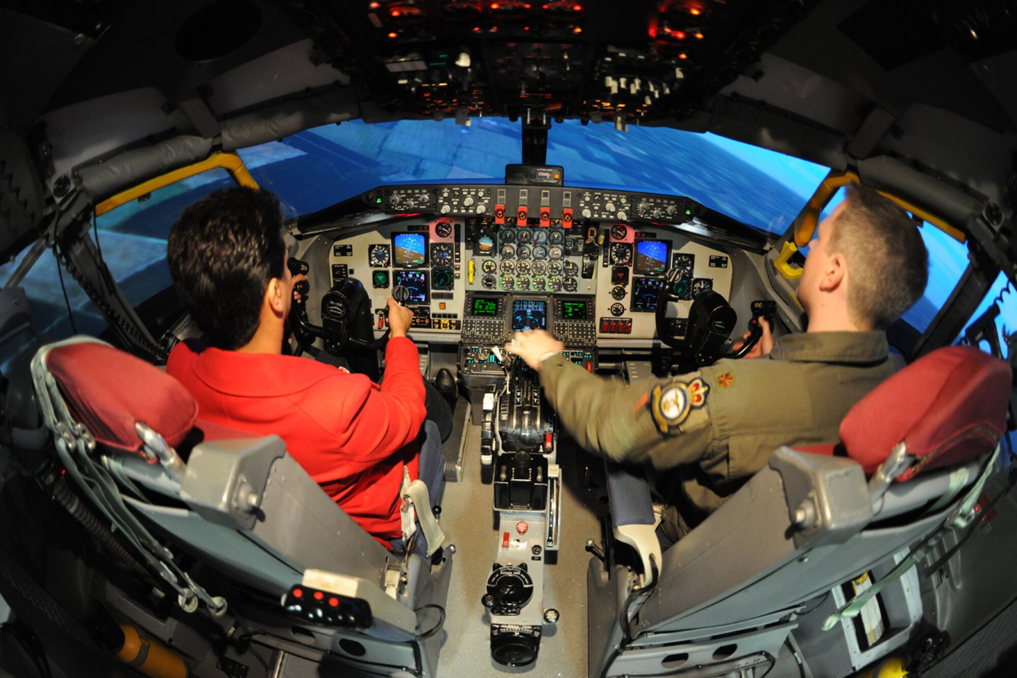 Maj. Chris Saettel, right, 351st Air Refueling Squadron instructor pilot, talks Karen Abeyasekere, 100th Air Refueling Wing Public Affairs, through the controls of the simulator cockpit, which is an exact replica of that in an actual KC-135 Stratotanker. (U.S. Air Force photo/Staff Sgt. Jerry Fleshman)