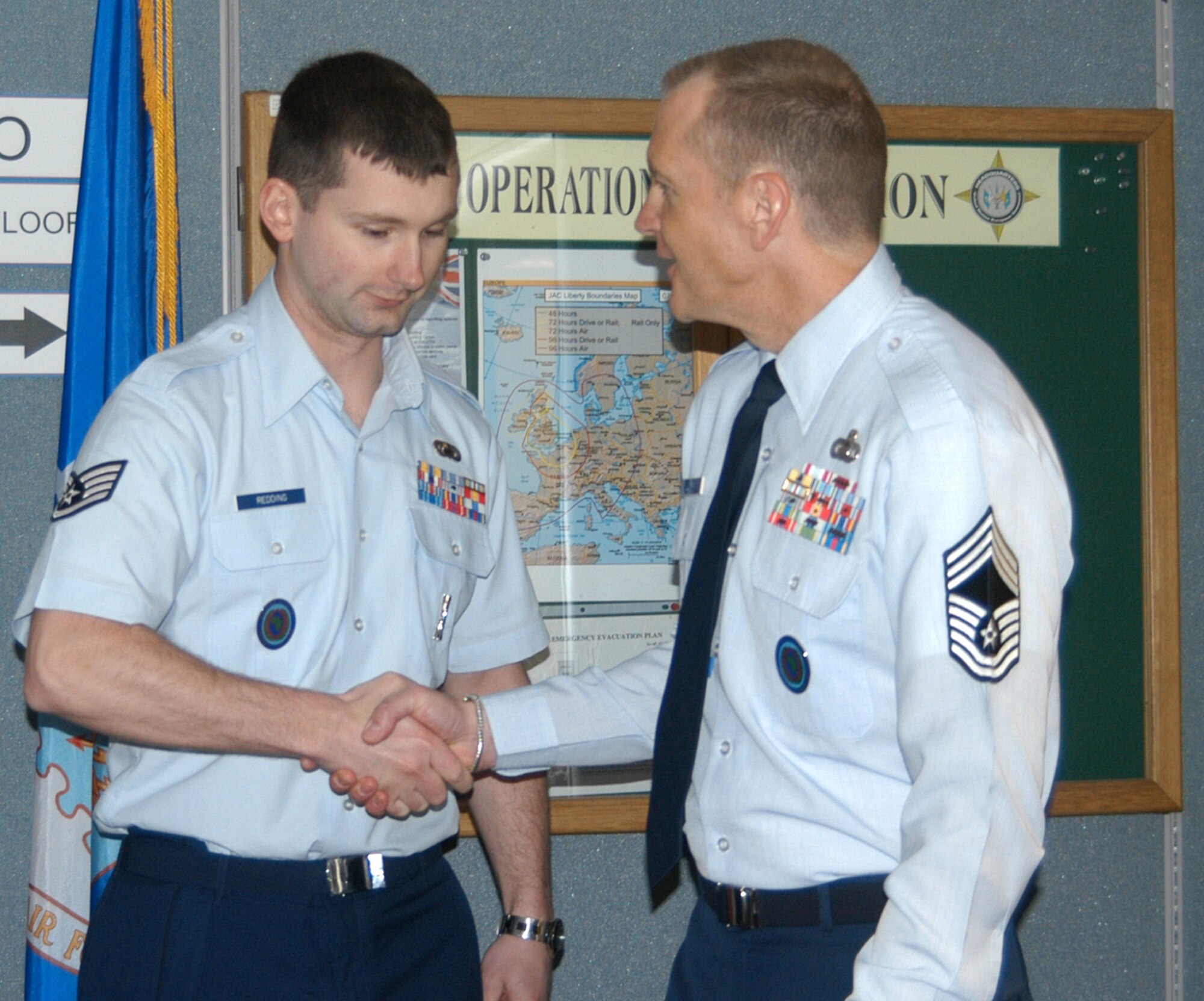 United States Air Force Chief Master Sgt. Scott W. Lumpkin (right), Senior Enlisted Leader for Intelligence and Knowledge Development Directorate-Molesworth congratulates United States Air Force Staff Sgt. Ian M. G. Redding (left) for winning the Air Force Association’s 2010 William H. Pitsenbarger Award (Photo by Melony Angelilli)