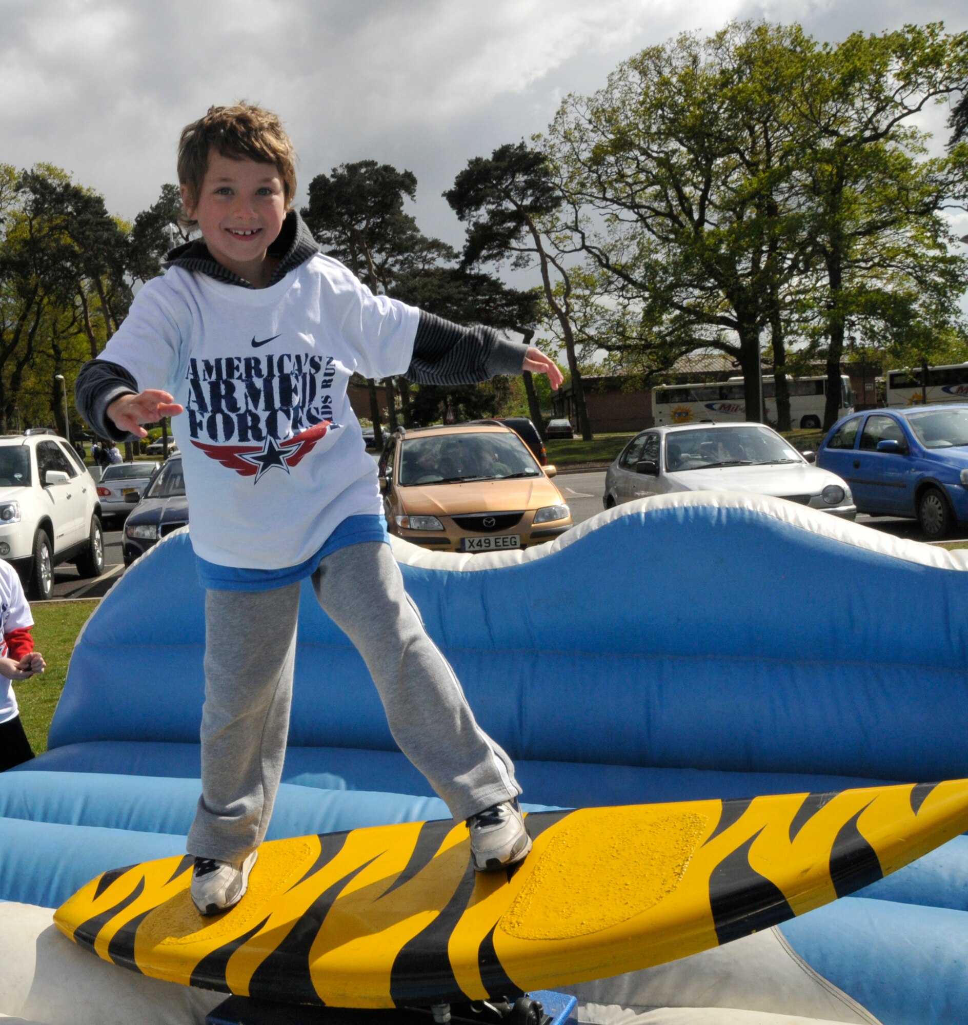 Nicholas Elkns, 9, son of Tech. Sgt. Nathan Elkins, 48th Civil Engineer Squadron fire inspector, rides the surf machine while other children watch before participating in the Armed Forces Kids' Run May 3. More than 50 families came out to be part of the 25th Annual Armed Forces Kids' Run. (U.S. Air Force photo/Airman 1st Class Eboni Knox)