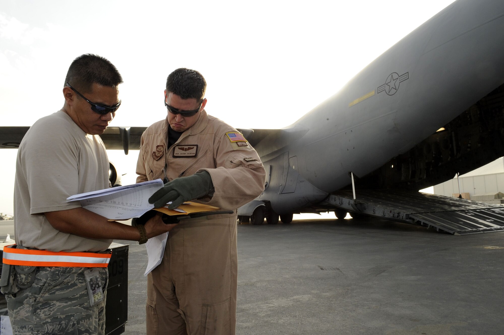Master Sgt. Stanley Bembo and Senior Airman Jason Jackson confirm cargo being offloaded from a C-17 on April 8 .  (U.S. Air Force photo by Senior Airman Nancy Hooks/Released)