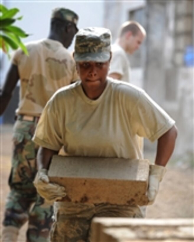 U.S. Air Force Senior Airman Shamika Moore, a member of the 127th Civil Engineering Squadron, Michigan Air National Guard, carries a cement building block at a work site in Accra, Ghana, on April 13, 2010.  The 127th Civil Engineering Squadron deployed to Ghana for two weeks in April to help perform a major renovation on a training building used by the air force of Ghana.  