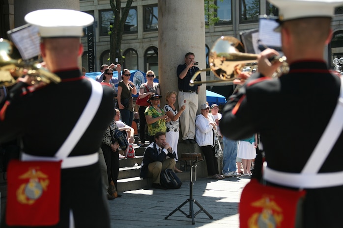 Local Boston residents watch Albany Marine Band performs, ''The Song of Marines,'' at Faneuil Hall Marketplace in Boston, Mass., May 4, 2010, for Marine Week Boston.  Albany Marine Band marched from Faneuil Hall Marketplace to Boston Common, playing several songs to include, ''Stars and Stripes, Marines' Hymn, What a Wonderful World and Semper Fi.''?The band's performance played a key role in Marine Week Boston to share the Corps' traditions, history and culture with Bostonians and help them learn about the Corps' value to the nation.