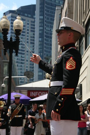Staff Sgt. Ignatius J. Keogh, the enlisted conductor for Albany Marine Band and native of Rochester, N.Y., conducts band members as they play ''God Bless America,'' in downtown Boston, Mass., in a crowd of surrounding Bostonians, May 4, 2010. Albany Marine Band performed several songs to include, ''Stars and Stripes, Marines' Hymn, What a Wonderful World and Semper Fi.''?The band's performance played a key role in Marine Week Boston to share the Corps' traditions, history and culture with Bostonians and help them learn about the Corps' value to the nation.