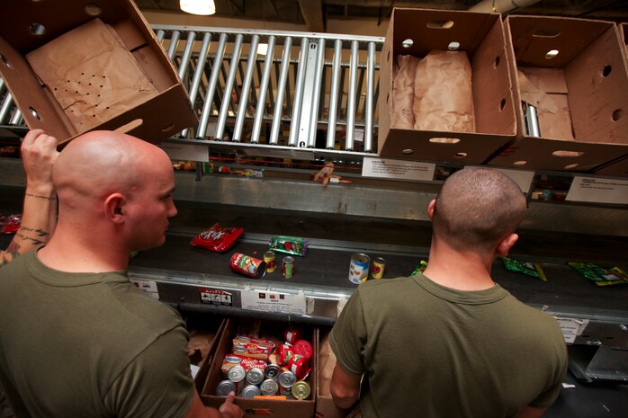 Marines with Company L, 3rd Battalion, 24th Marine Regiment, process and package canned and other sealed goods while lending a hand at the Great Boston Food Bank May 4, 2010. The Marines are volunteering in support of Marine Week Boston, where they'll provide service to community groups, host physical fitness challenges and sports clinics in city parks and showcase state-of-the-art Marine vehicles, aircraft and equipment.