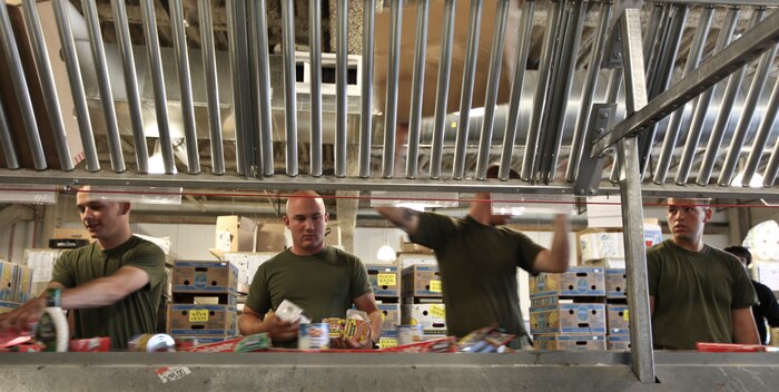 Marines with Company L, 3rd Battalion, 24th Marine Regiment, process and package canned and other sealed goods while it's going by an a conveyor belt - lending a hand at the Great Boston Food Bank May 4, 2010. The Marines are volunteering in support of Marine Week Boston, where they'll provide service to community groups, host physical fitness challenges and sports clinics in city parks and showcase state-of-the-art Marine vehicles, aircraft and equipment.
