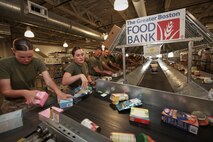 Lance Cpl. Eric Carrouth, a native of Boiling Springs, S.C., serving with Company L, 3rd Battalion, 24th Marine Regiment, checks the expiration date on a canned food item as he assists the Great Boston Food Bank May 4, 2010. The Marines are volunteering in support of Marine Week Boston, where they'll provide service to community groups, host physical fitness challenges and sports clinics in city parks and showcase state-of-the-art Marine vehicles, aircraft and equipment.