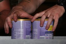 A Marine picks up two jars of canned food to check for quality before placing them in a box in the Greater Boston Food Bank in Boston May 4, 2010. The volunteer work was part of Marine Week Boston, a weeklong series of events that give Boston residents a chance to interact with Marines and learn about the Corps’ culture, history and current missions.