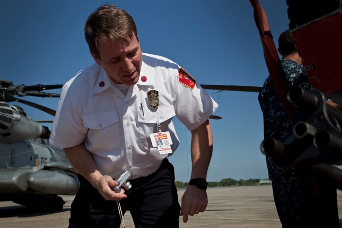 Capt. John Dolan, logistics officer with the Boston Fire Department inspects an AH-1W Super Cobra at Hanscom Air Force Base May 4, 2010. The Marine helicopter was at the air base in support of Marine Week May 3-9.