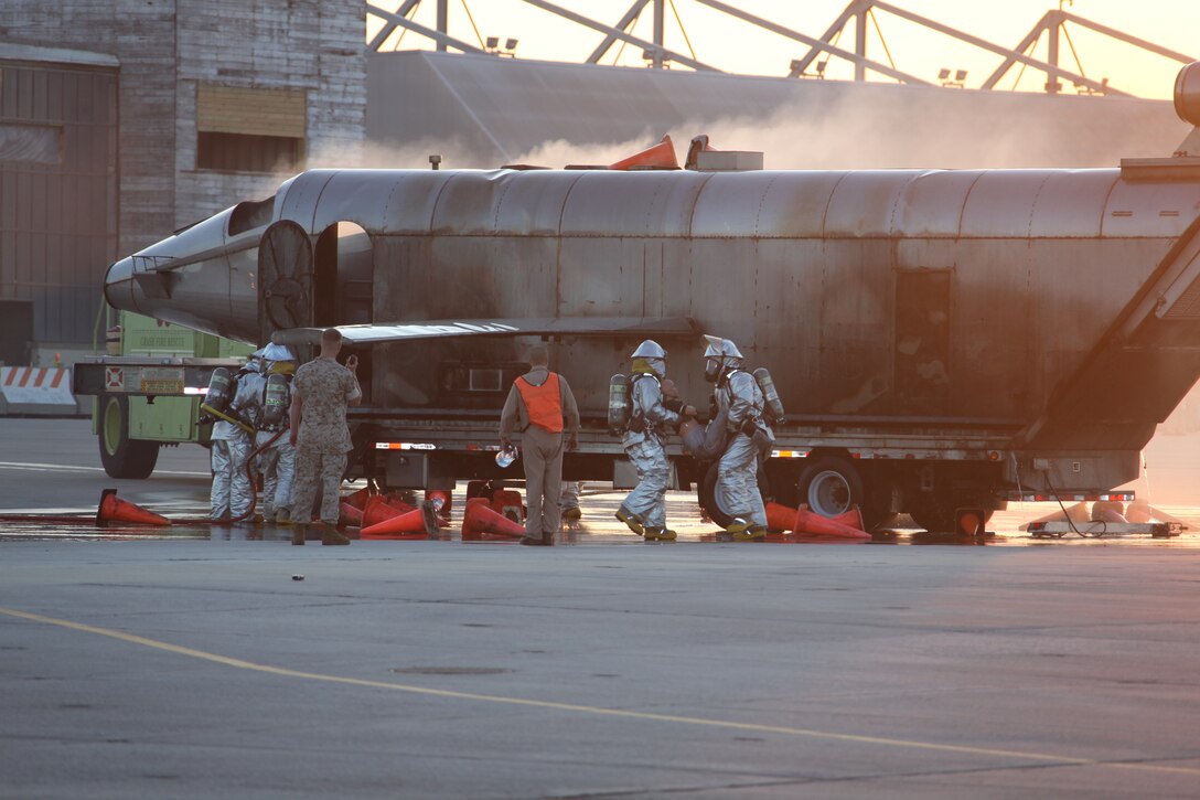 Aircraft rescue firefighters defuse a fire and rescue a simulated injured person at the mass casualty exercise, May 5. The scenario consisted of a terrorist coming onto the air station posing as a vendor and boarded the static aircraft where he planted a bomb and detonated it. Marines and Sailors simulated the victims of the attack. There were eight simulated deaths and more than 20 simulated victims.