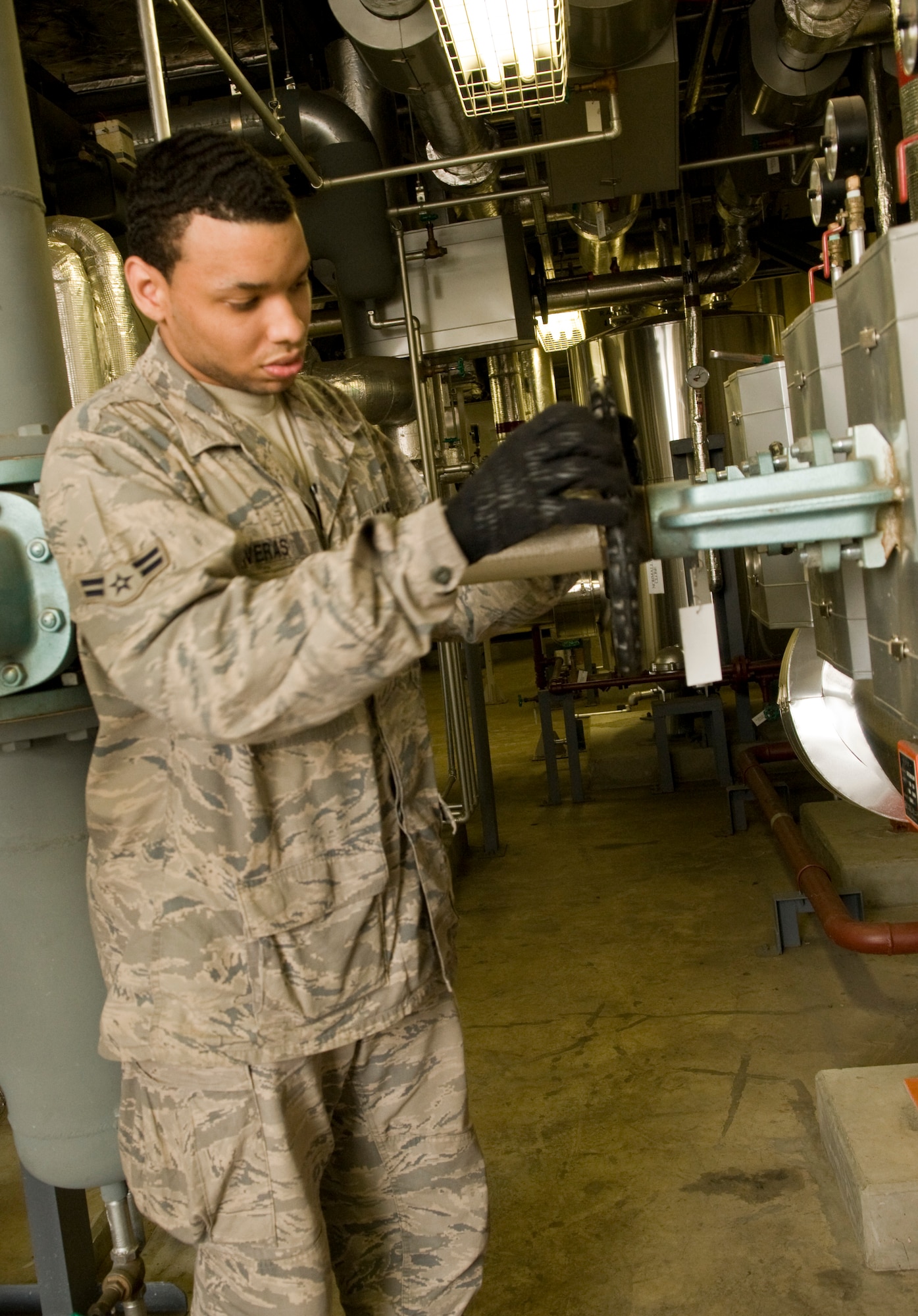 Airman 1st Class Omar Taveras, a 35th Civil Engineer Squadron Heating Ventilation and Air conditioning technician, loosens the pressure valve on a steam header to cut off heat to Building 656, April 4. Due to Misawa’s recent warm weather, members from the 35th CES will initially turn the heat off to more than 500 facilities base-wide, followed by facilities in base housing in late May. (U.S.  Air Force photo/ Senior Airman Jessica Lockoski)
