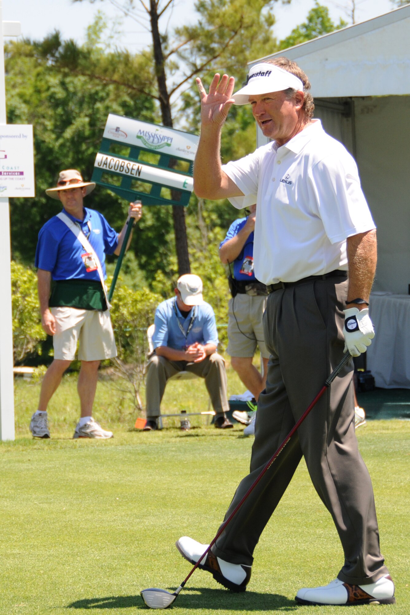 Volunteer Joel Riley, left, 334th Training Squadron, carries a sign for pro golfer Peter Jacobsen on Hole 10 April 29 at Fallen Oaks Golf Club in Saucier.  (U.S. Air Force photo by Kemberly Groue)