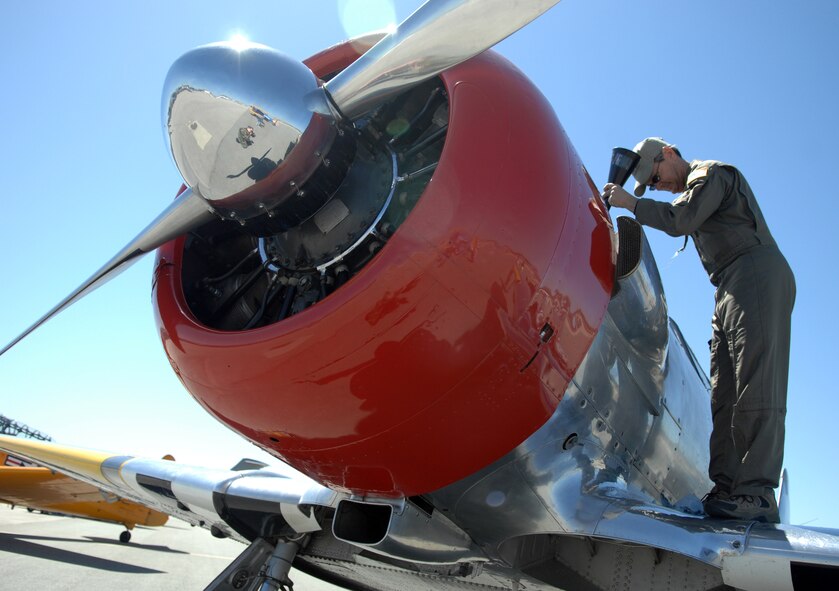An AirFest performer inspects his aircraft at the March Field AirFest, March Air Reserve Base, Calif., May 2, 2010. The AirFest is a bi-annual, two-day event featuring military and civilian aerial performances and static displays of modern and historic aircraft. (U.S. Air Force photo by Senior Airman Sean Adams/released)