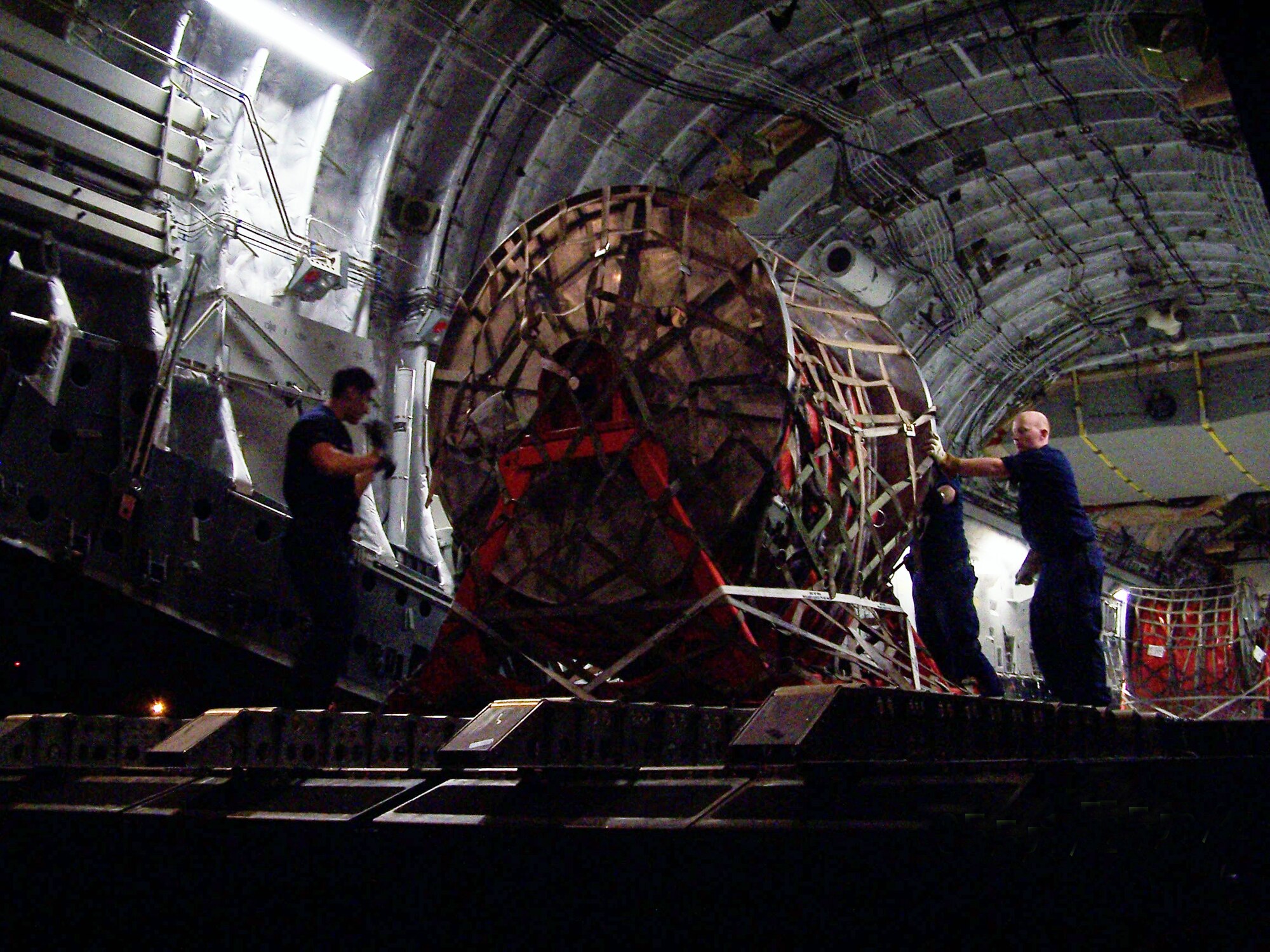 A Reserve Coast Guard crew offloads rolls of inflatable boom from a C-17 Globemaster III from Travis Air Force Base; Calif.; Active duty and Air Force Reserve personnel from Travis AFB partnered with the U.S. Coast Guard May 2 to get desperately needed equipment to the oil-ravaged waters of the Gulf of Mexico. The cargo included 10 reels of inflatable boom, to be positioned off shore to keep the oil slick from coming ashore. (Photo by U.S. Coast Guard Lt. J.G. Michael Oubre).