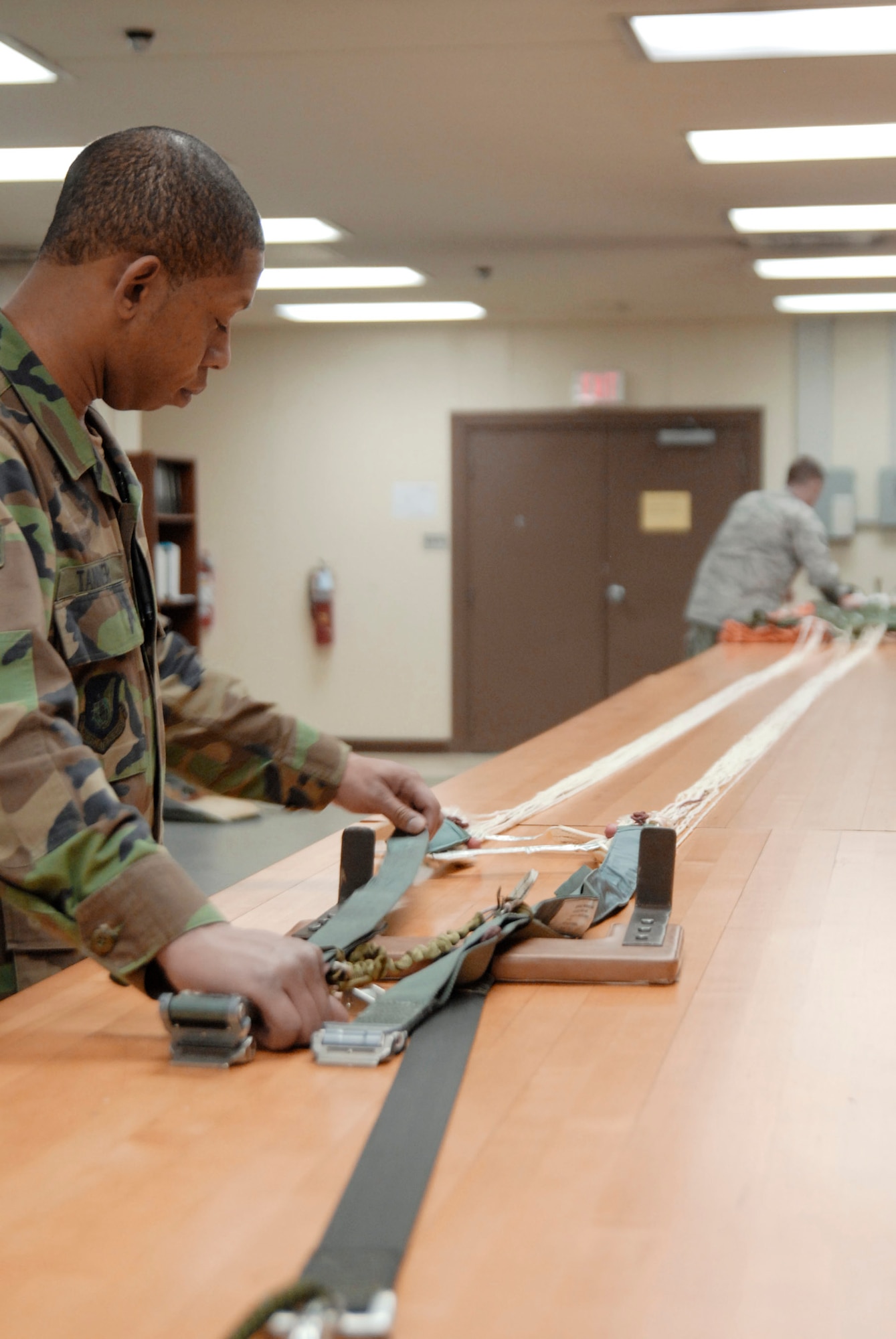Staff Sgt. Cortney Tanner and Tech. Sgt. Jonathan Anlauf inspect the lines of a canopy April 7, 2010, at Kunsan Air Base, South Korea. Airman Tanner is an aircrew flight equipment craftsman, and Sergeant Anlauf is the NCO in charge of the AFE. Both are assigned to the 8th Operations Support Squadron. (U.S. Air Force photo/Staff Sgt. Darnell T. Cannady) 
