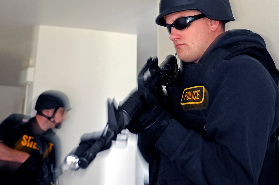 ELLSWORTH AIR FORCE BASE, S.D. – Police officers provide security during a simulated search warrant scenario as part of a basic SWAT team training exercise, May 4. Base housing offered a comprehensive training environment that gave the officers a realistic atmosphere for clearing houses. (U.S. Air Force photo/Airman 1st Class Matthew Flynn)