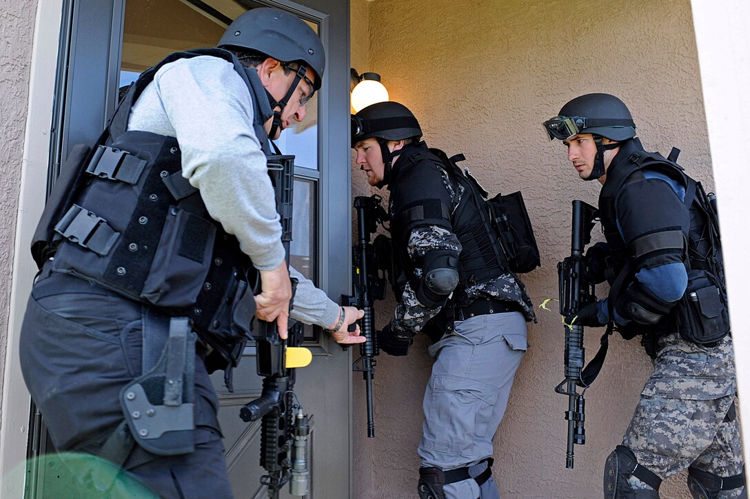 ELLSWORTH AIR FORCE BASE, S.D. – Police officers begin to enter a home during a simulated search warrant scenario as part of a basic SWAT team training exercise, May 4.  The 28th Security Forces Squadron opened two vacant homes to allow police officers from nine different agencies to train. (U.S. Air Force photo/Airman 1st Class Matthew Flynn)