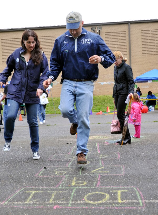 Airman 1st Class Caitlin Carter, left, 779th Medical Operations Squadron mental health technician, coaches Army Capt. Jeff Wood on how to hop scotch during a FitFactor exercise to test his coordination and agility at Joint Base Andrews, Md., April 24, 2010. Captain Wood is assigned to the 1st Squadron - 158th Cavalry Regiment, Annapolis, Md.