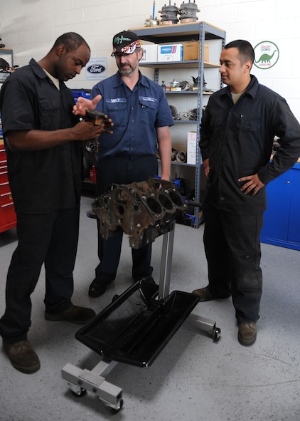 DYESS AIR FORCE BASE, Texas-- Lonnie Thompson, 7th Logistics Readiness Squadron vehicle maintenance trainer, trains two vehicle maintenance technicians on the basics of rebuilding an engine May 4 here. Airmen in the vehicle maintenance shop are required to complete 121 core tasks for upgrade training. The vehicle maintenance shop is in charge of numerous duties that keep our government vehicles running throughout Dyess. (U.S. Air Force photo/ Airman 1st Class Brittney Prescott)
