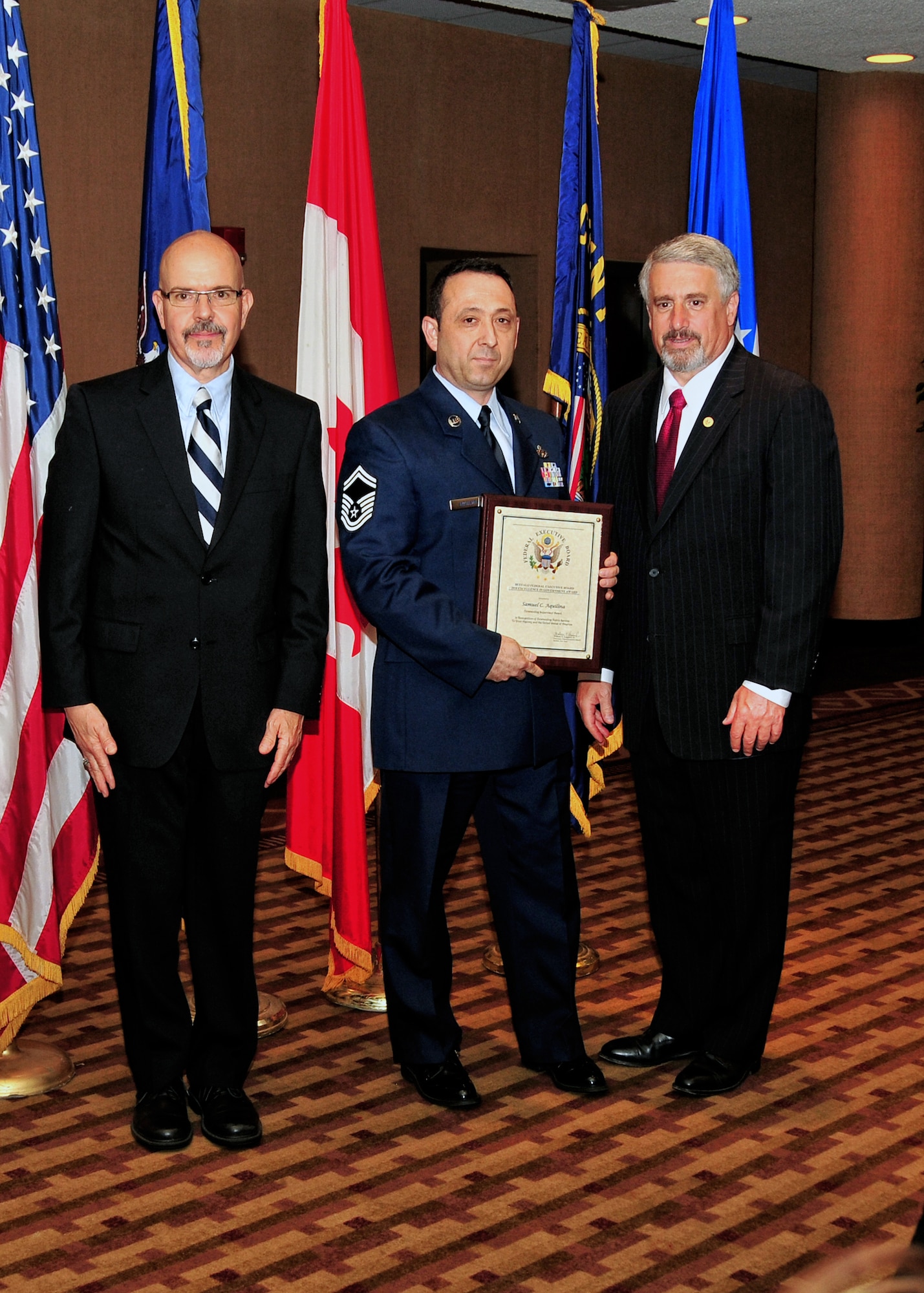 U.S. Air Force Senior Master Sgt. Samuel C. Aquilina, 914th Airlift Wing (center) receives the Outstanding Supervisor Award, May 4, 2010, Buffalo NY. The Buffalo Federal Executive Board Excellence in Government luncheon celebrating excellence in public service was held in the Buffalo convention center. (U.S. Air Force photo by Staff Sgt. Joseph McKee)