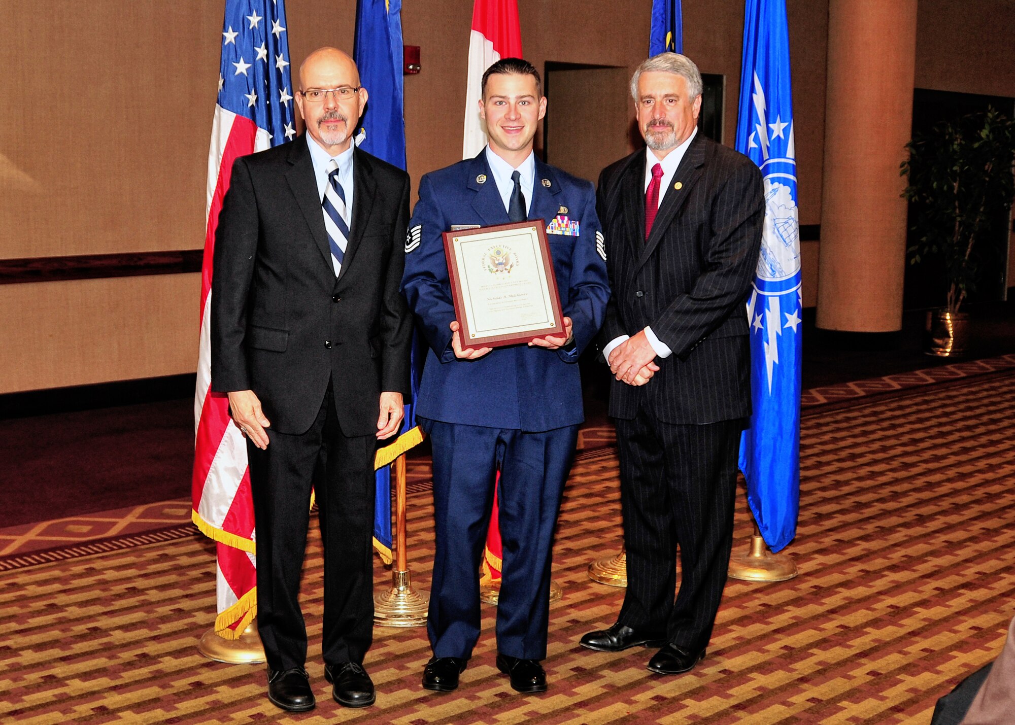 U.S. Air Force Technical Sgt. Nicholas A. Melchiorre, 914th Airlift Wing (center) receives the Distinguished Government Service Award, May 4, 2010, Buffalo NY. The Buffalo Federal Executive Board Excellence in Government luncheon celebrating excellence in public service was held in the Buffalo convention center. (U.S. Air Force photo by Staff Sgt. Joseph McKee)