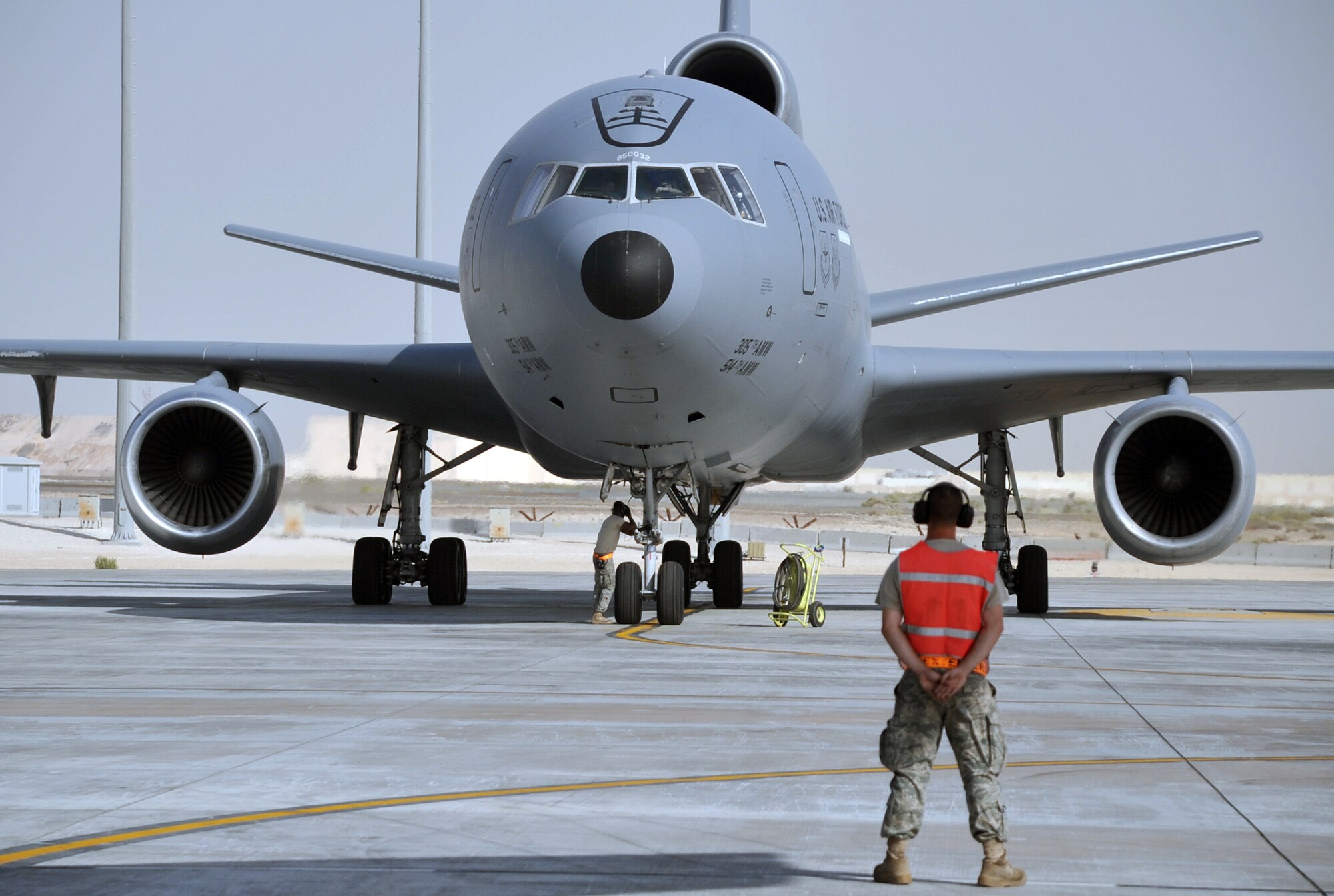 A maintenance Airman assigned to the 380th Expeditionary Aircraft Maintenance Squadron Extender aircraft maintenance unit stands at parade rest as he prepares to help guide a KC-10 Extender from the 908th Expeditionary Air Refueliung Squadron that is departing for a mission on April 20, 2010. In the first three months of 2010, Airmen supporting the KC-10 deployed air refueling in the U.S. Central Command area of responsibility flew more than 1,000 sorties offl-loading more than 108 million pounds of fuel to more than 6,600 aircraft in support of combat operations. The 908th EARS and the 380th EAMXS, as part of the 380th Air Expeditionary Wing, support operations Iraqi Freedom and Enduring Freedom and the Combined Joint Task Force-Horn of Africa. (U.S. Air Force Photo/Master Sgt. Scott T. Sturkol/Released)