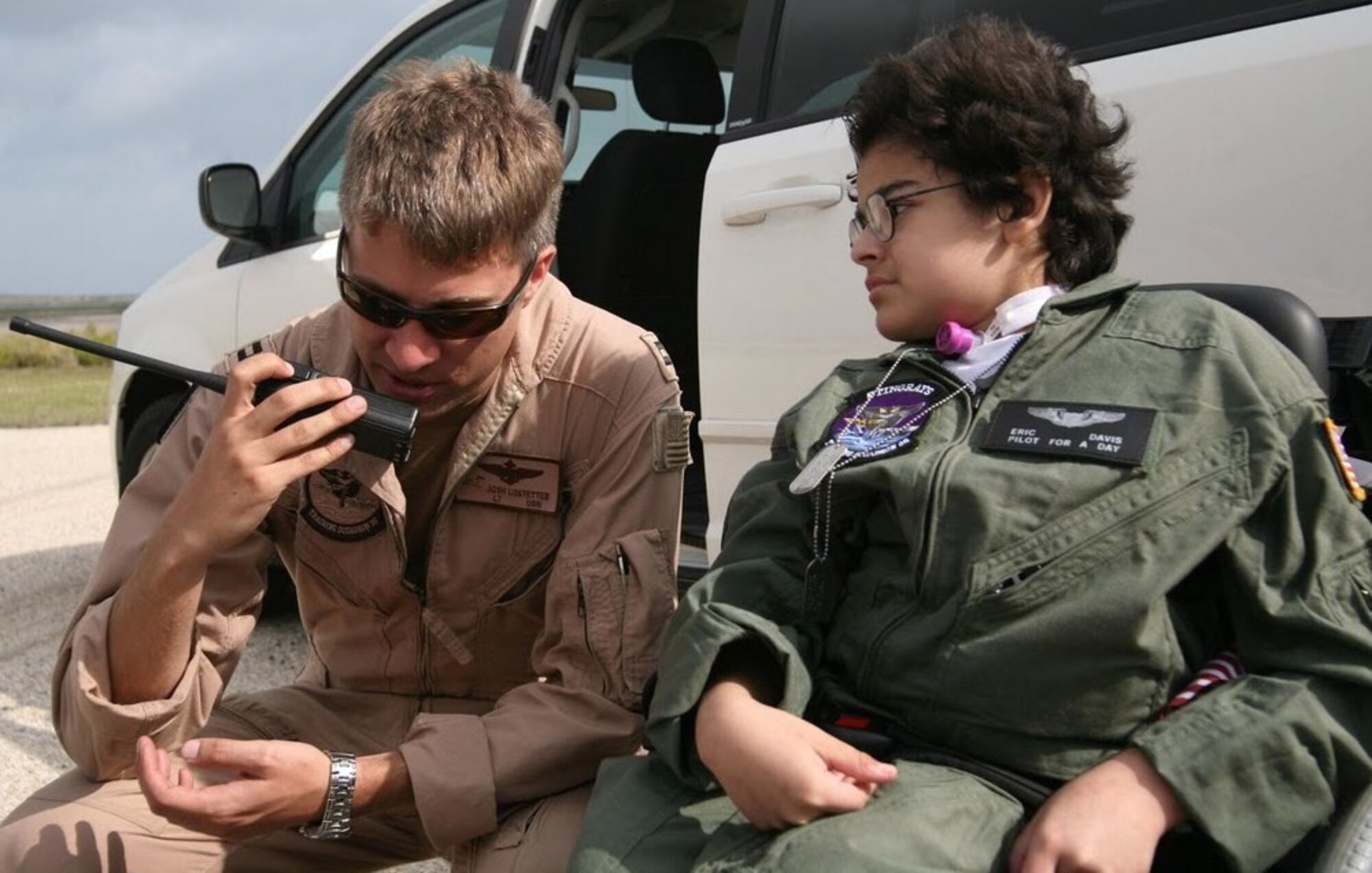 NAVAL AIR STATION CORPUS CHRISTI, Texas -- Pilot-For-A-Day participant Eric Davis (right) and Navy Lt. Josh Lostetter, talk to pilots in the cockpit of a B-52 from the 2d Bomb Wing’s 20th Bomb Squadron as it flies over the runway in support of the Pilot-For-A-Day program. When scheduling allows, the 2d Bomb Wing uses the missions to practice off station low approaches while at the same time providing support for the program. (U.S. Coast Guard photo by Charles Dekle)