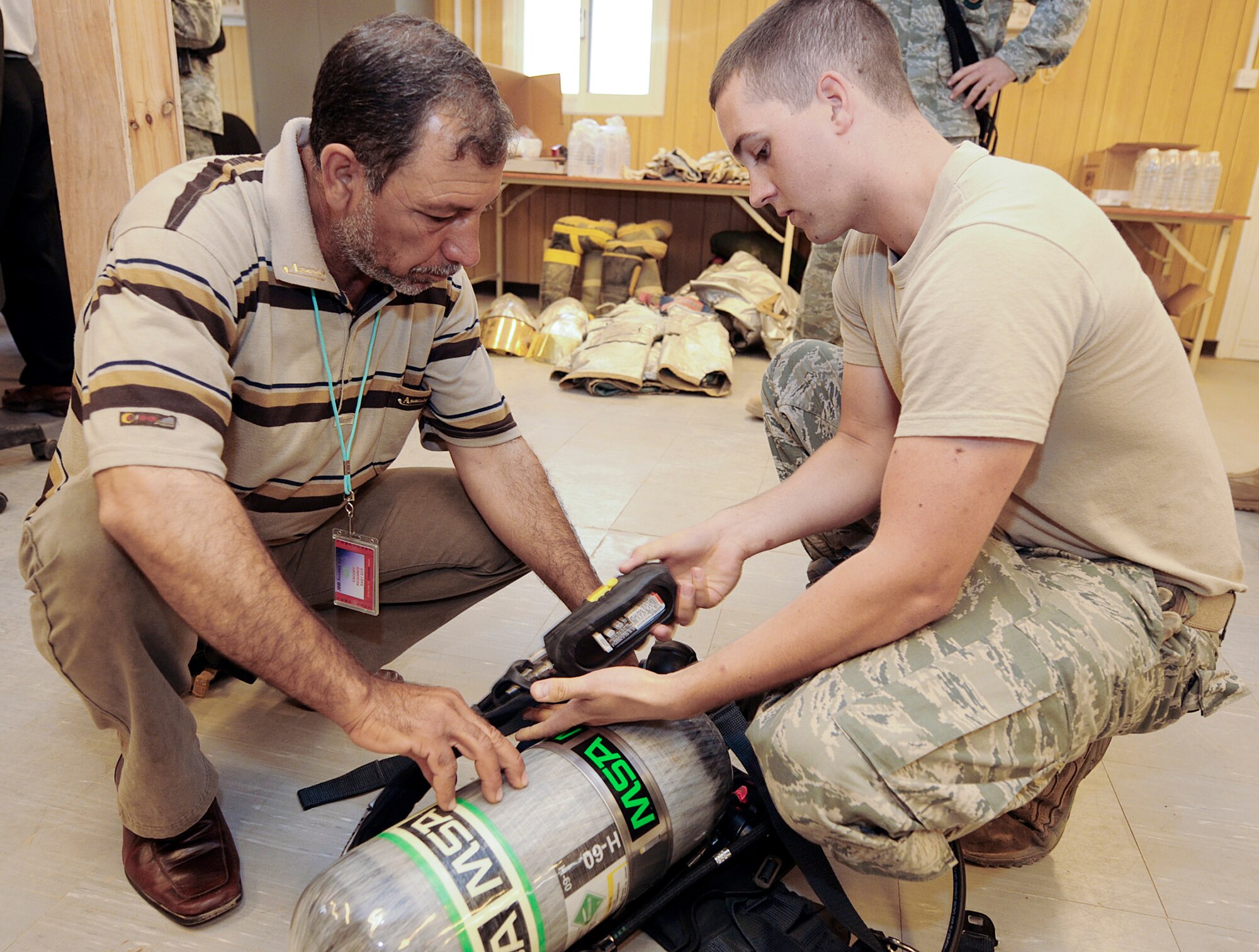 Airman 1st Class Colton Balthazor shows an Iraqi firefighter how to operate an oxygen tank during training April 30, 2010, at Joint Base Balad, Iraq. Airman Balthazor is a 332nd Civil Engineer Squadron firefighter deployed from Anderson Air Force Base, Md. (U.S. Air Force photo by Master Sgt. Linda C. Miller) 
