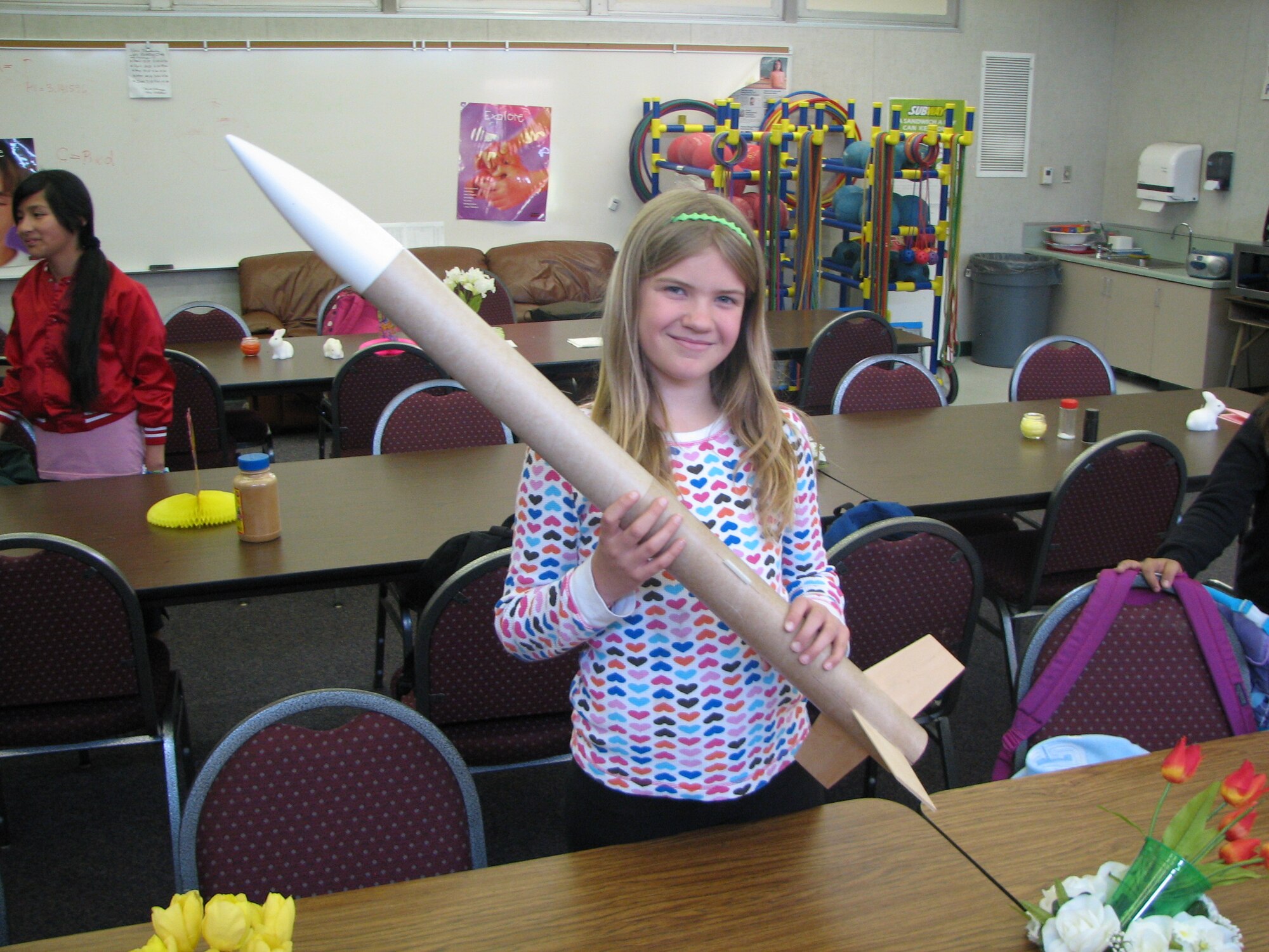 Samantha Blanchard holds up her rocket at Mariposa Elementary School.  The 9-year-old fifth grader launched the rocket with a Barbie doll in it during a test launch April 27.  She is one of 60 Mariposa and Linda Verde Elementary school children who take part in the school district's first rocket club.  Revell Walker, an Edwards Air Force Base engineer, is the club mentor and has been invited to teach classes on rocketry and space history to local children for the past nine years.  (Courtesy photo)