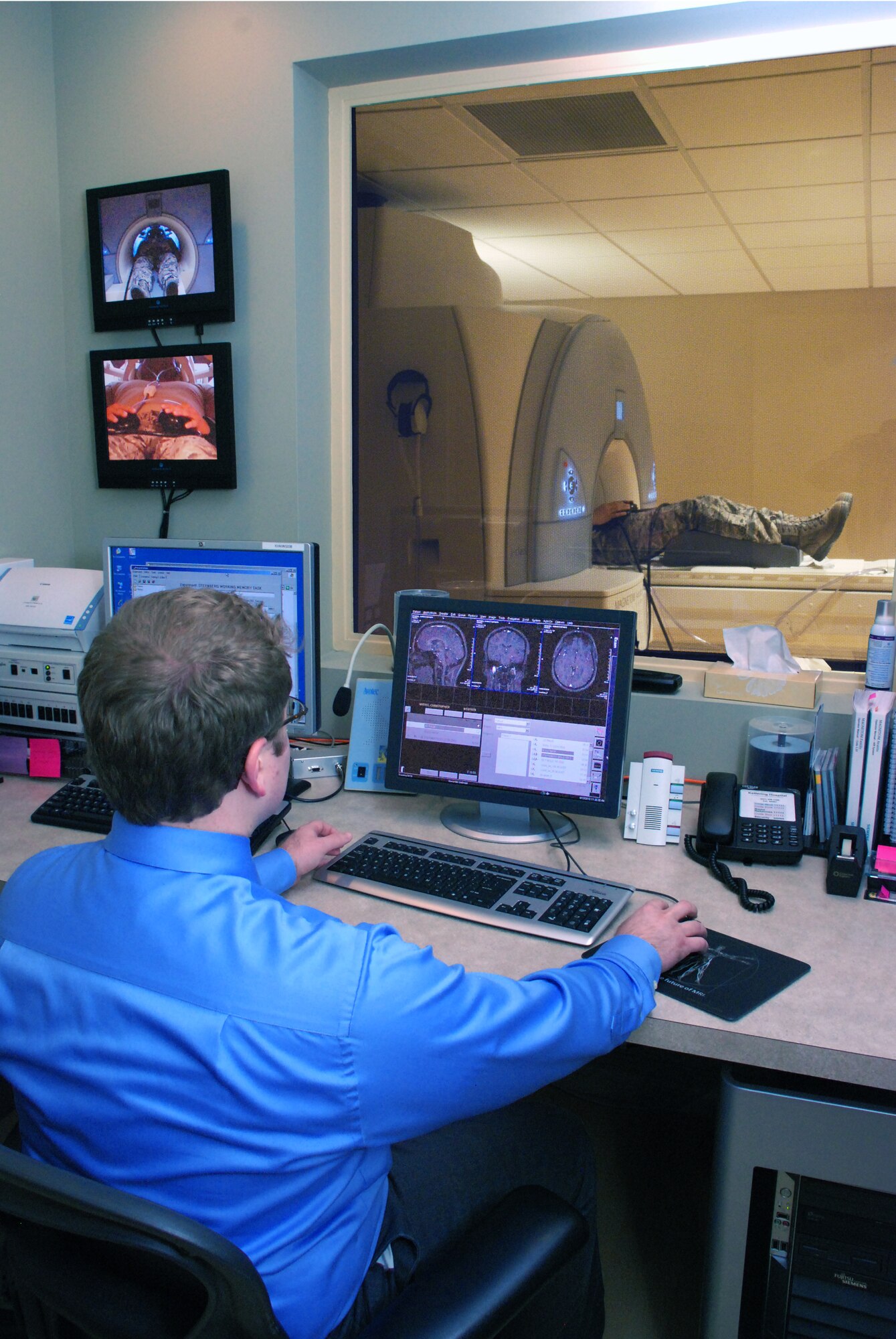 Eric Zalusky, Research Technologist at the Kettering Innovation Center, Kettering, Ohio, conducts fatigue research on Technical Sergeant Chris Myers, an Aircrew Flight Equipment Craftsman with the711th Human Performance Wing, Human Effectiveness Directorate, Biosciences and Performance Division, Vulnerability Analysis Branch (711 HPW/RHPA) at Wright-Patterson Air Force Base, Ohio. As part of the research, Technical Sergeant Myers takes a memory test as a functional MRI scans his brain so scientists can determine which areas of his brain are changing as he applies his memory. (Photo by Chris Gulliford, 711 HPW)